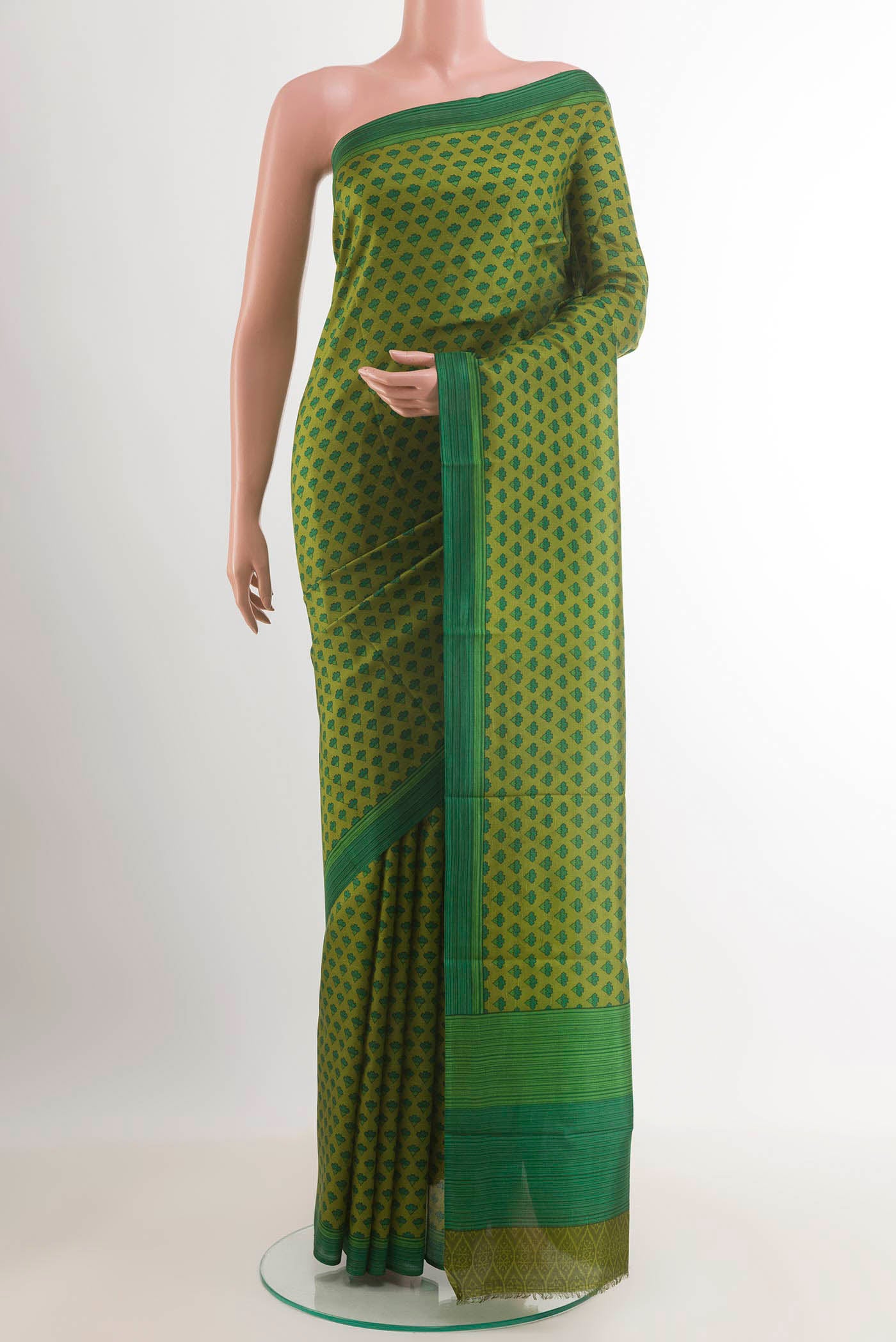 Green Printed Silk Saree with Printed design on the body and Plain Border.  displayed on a mannequin