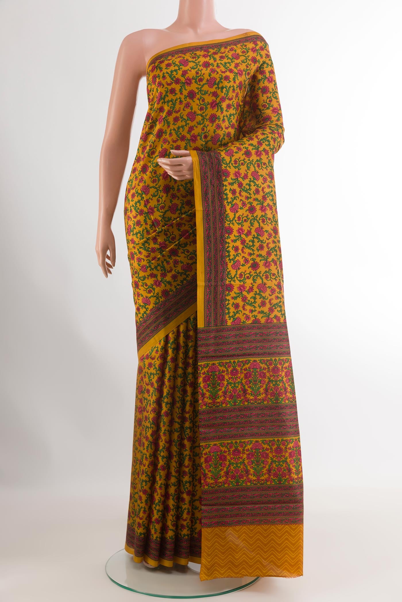 Mustard Printed Silk Saree with Printed design on the body and Printed Border.  displayed on a mannequin