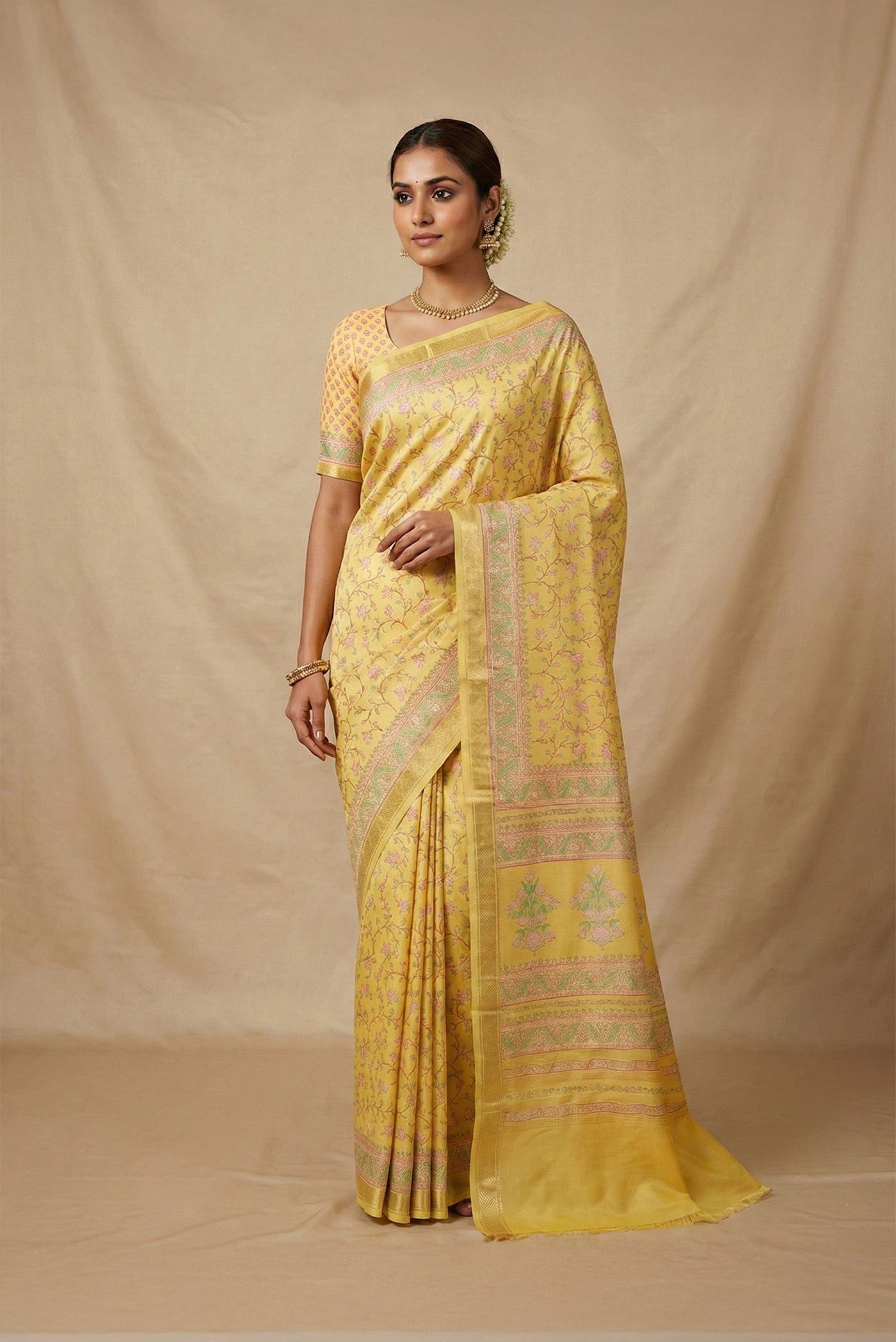 Model wearing a Yellow Printed Silk Saree with Printed design on the body and Zari Border.