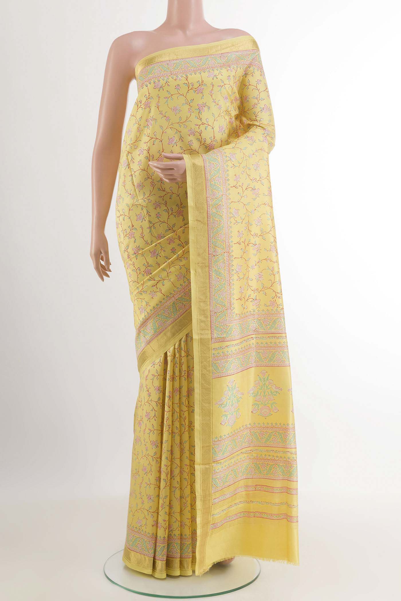 Yellow Printed Silk Saree with Printed design on the body and Zari Border.  displayed on a mannequin