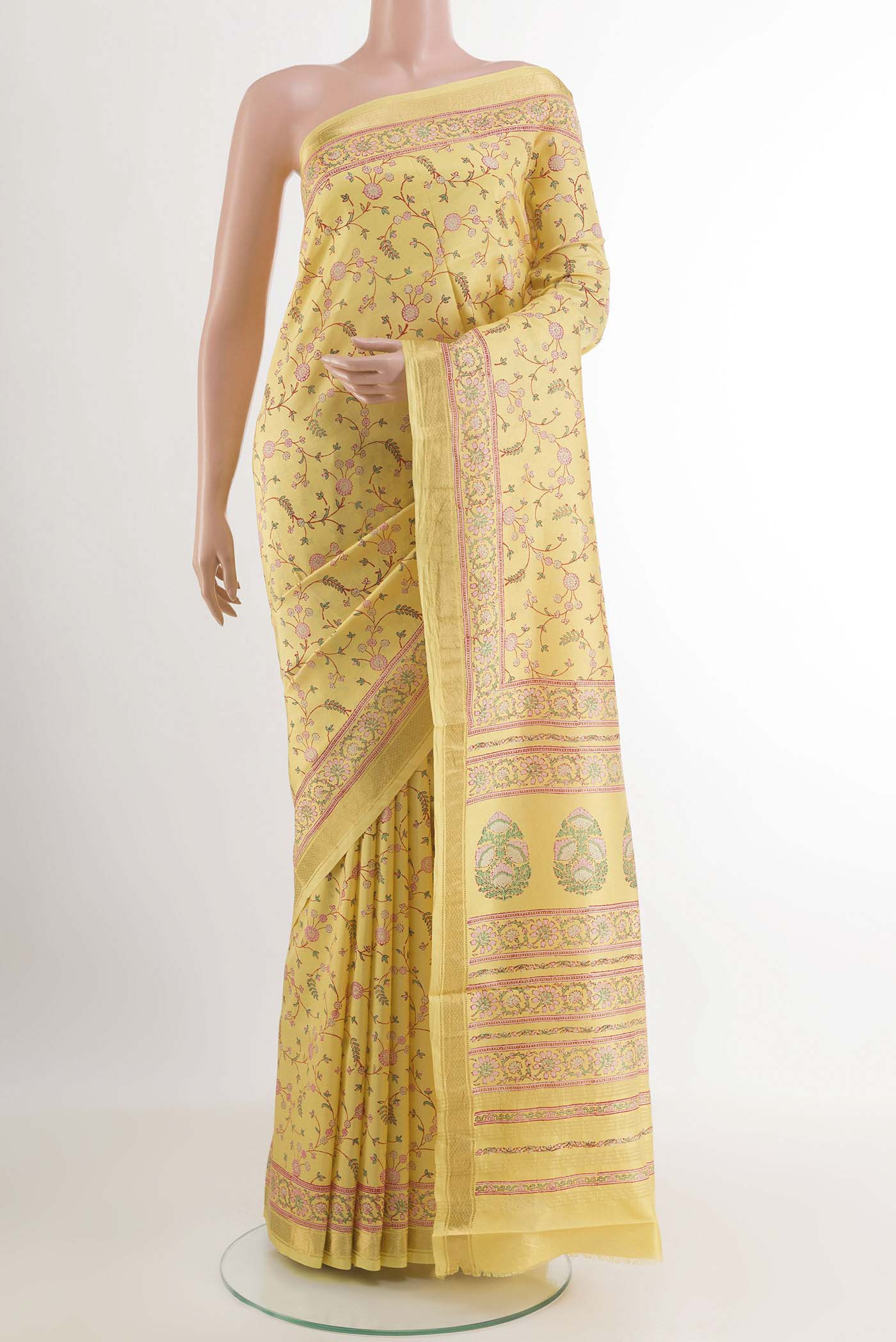 Yellow Printed Silk Saree with Printed design on the body and Zari Border.  displayed on a mannequin