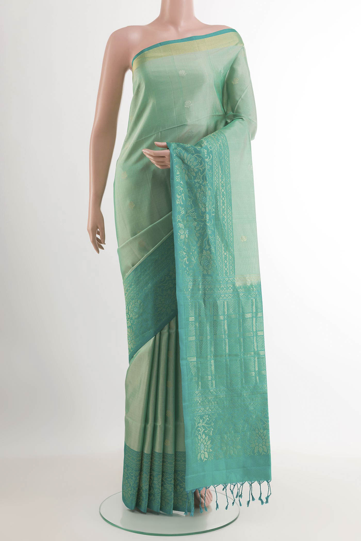 Sage Green Soft Silk Saree with Zari Butta on the body and Zari Border.  displayed on a mannequin