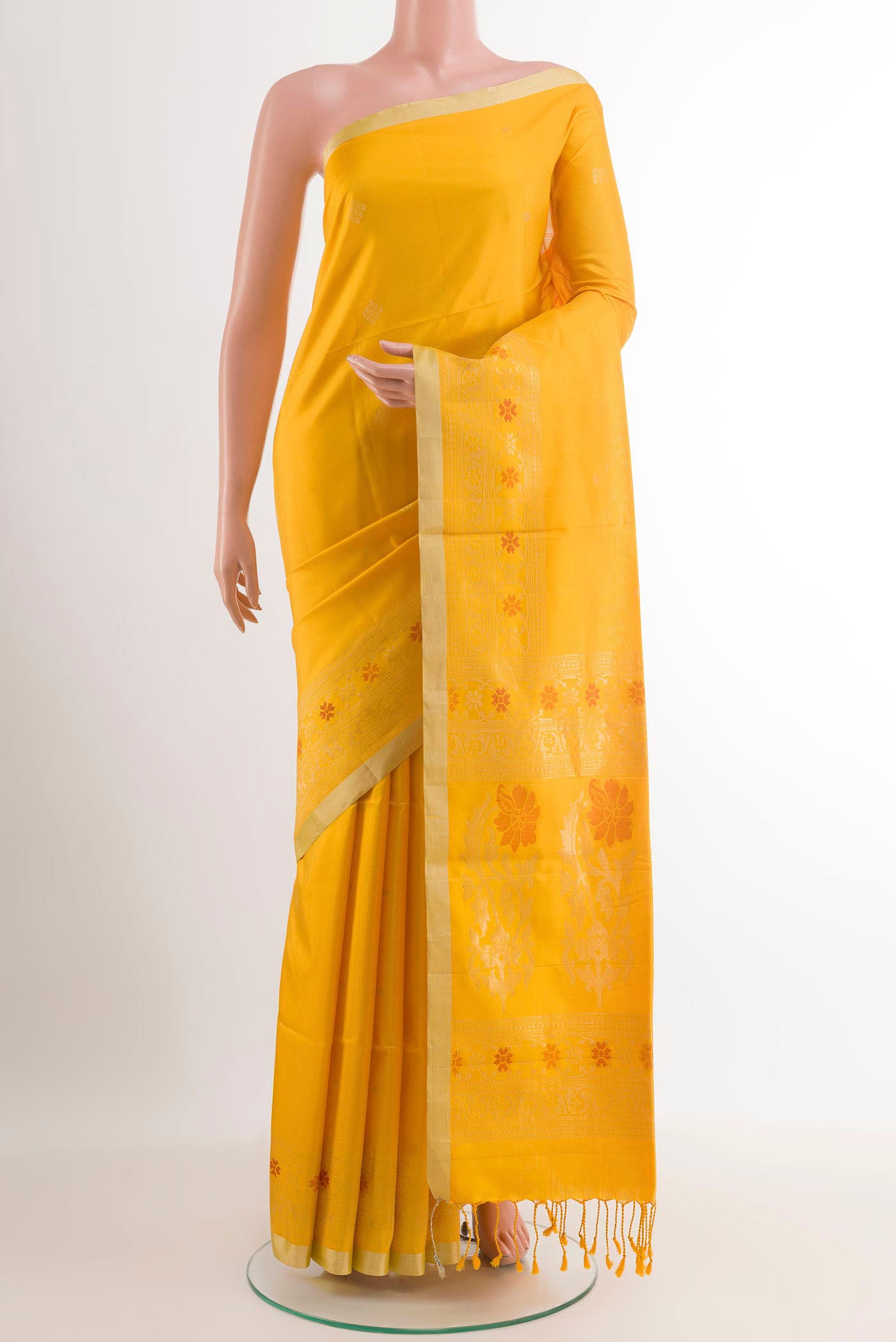 Yellow Soft Silk Saree with Zari Butta on the body and Zari Border.  displayed on a mannequin