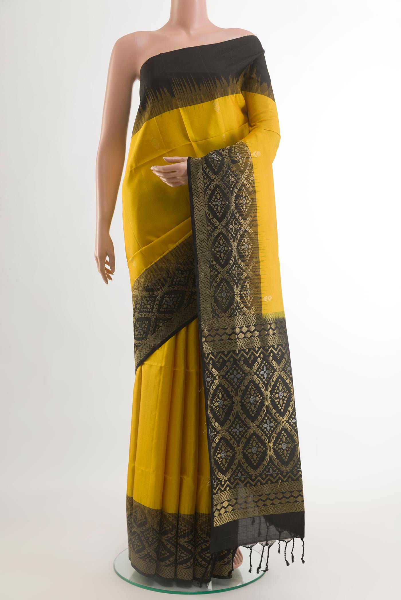 Yellow Soft Silk Saree with Zari Butta on the body and Zari Border.  displayed on a mannequin