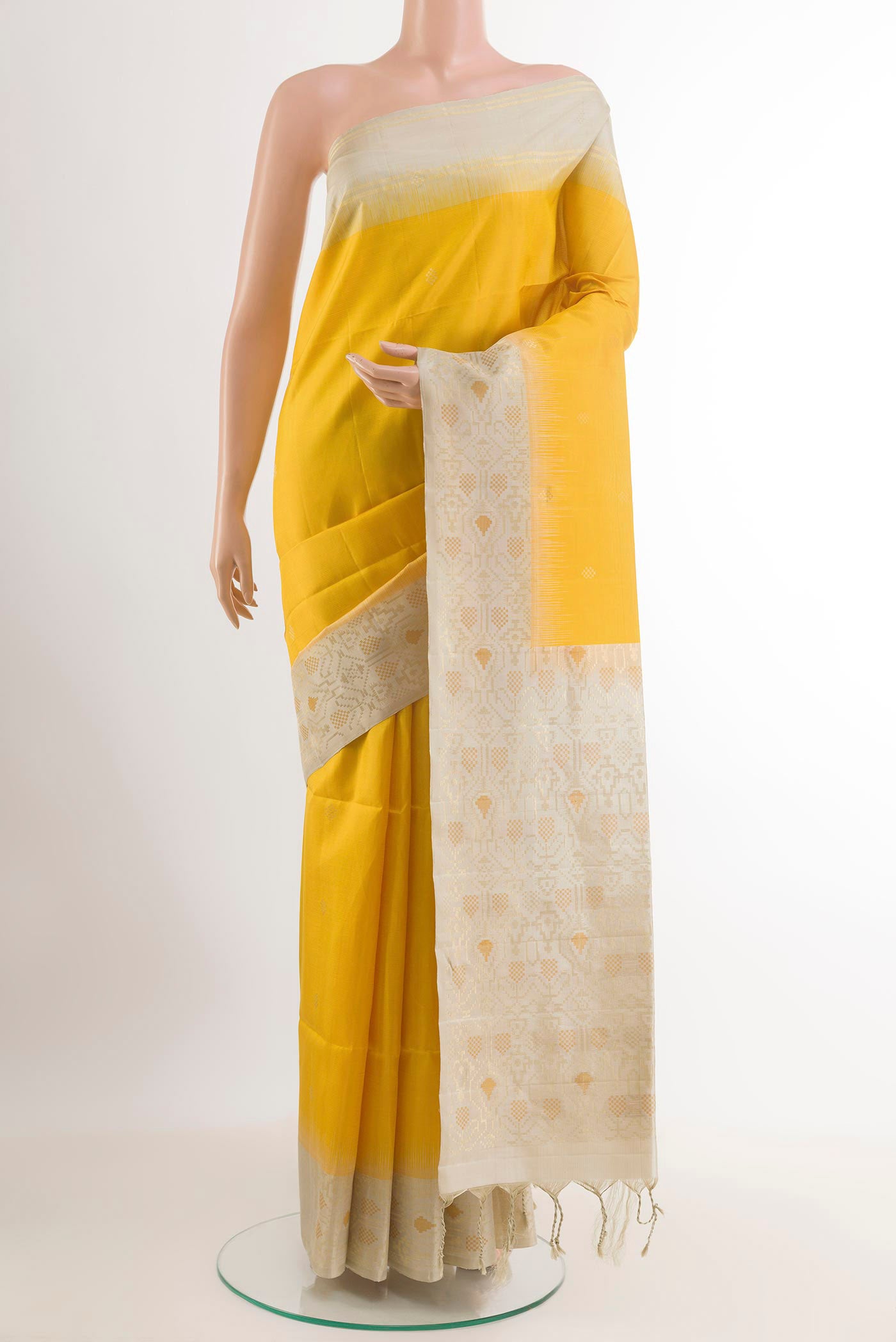 Yellow Soft Silk Saree with Zari Butta on the body and Zari Border.  displayed on a mannequin