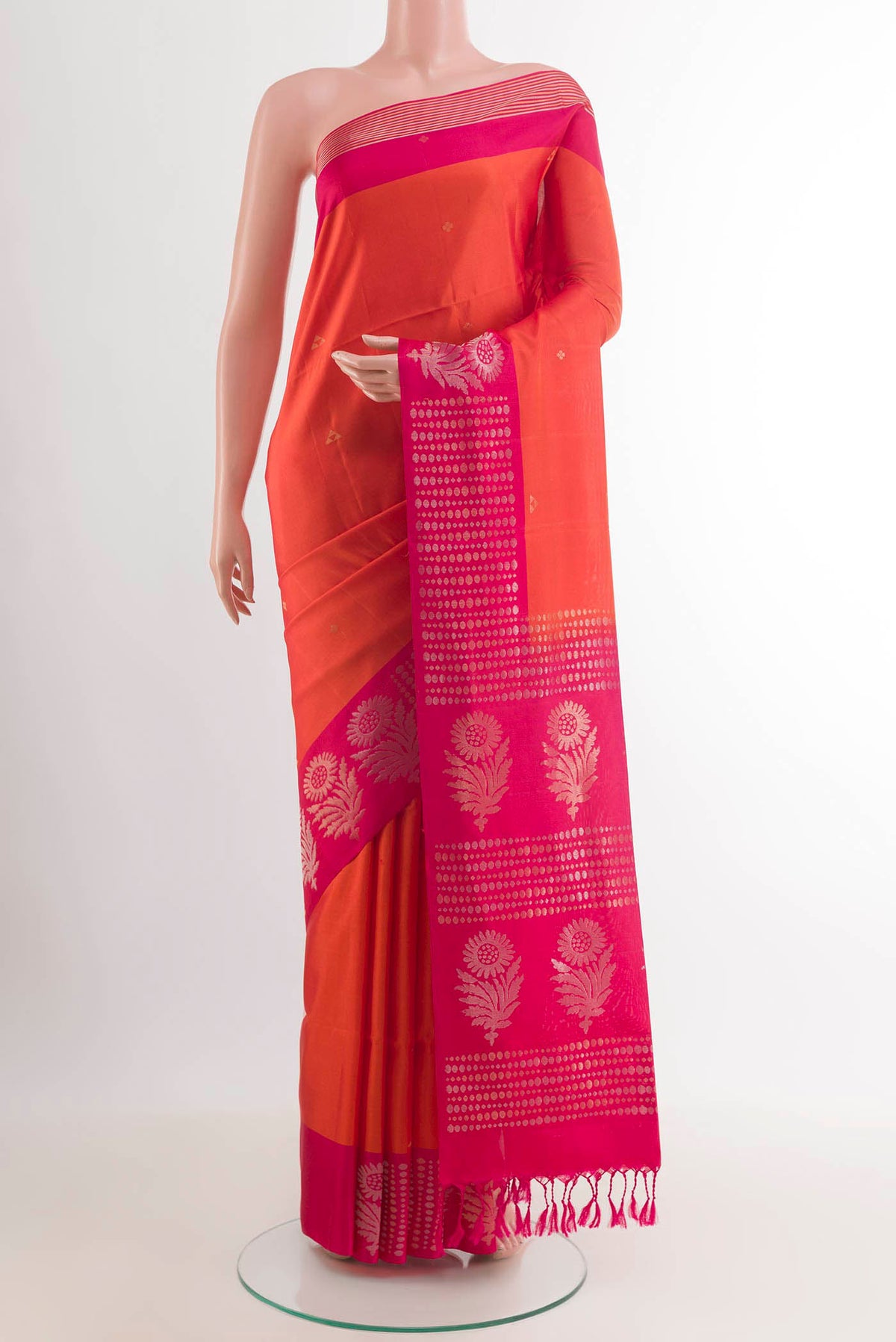 Orange Soft Silk Saree with Zari Butta on the body and Zari Border.  displayed on a mannequin