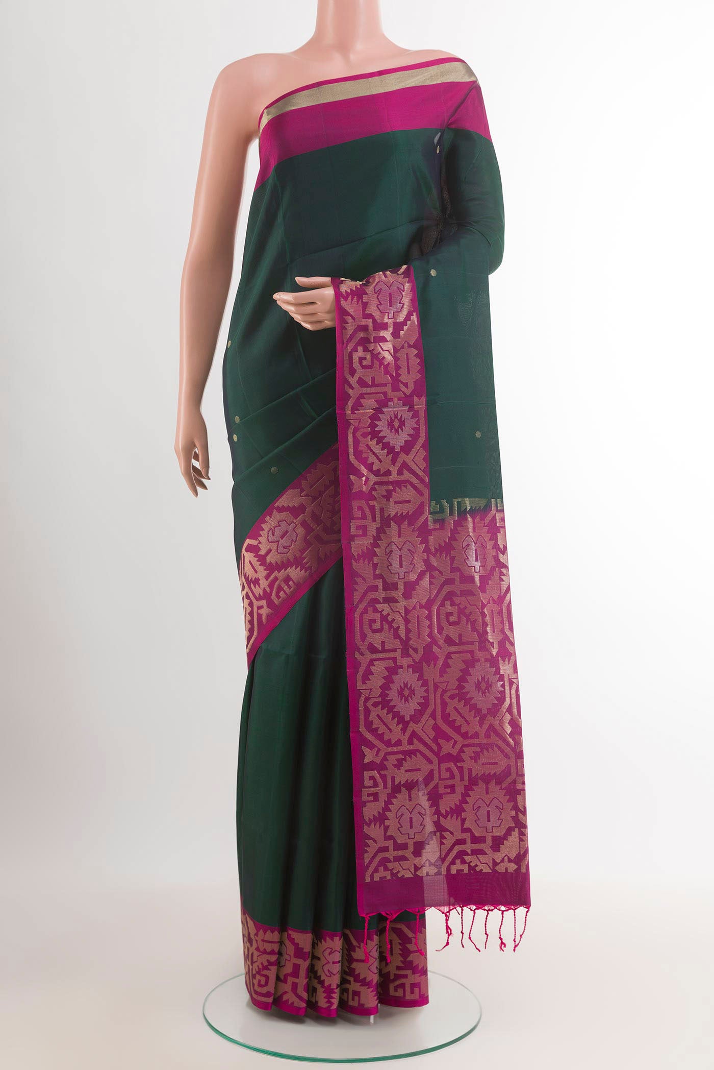 Bottle Green Soft Silk Saree with Zari Butta on the body and Zari Border.  displayed on a mannequin