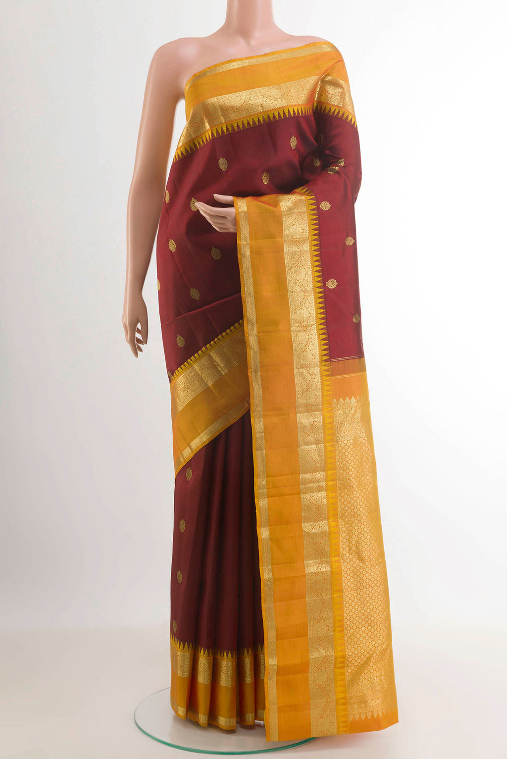 Maroon Kanchipuram Silk Saree with Zari Butta on the body and Zari Border.  displayed on a mannequin