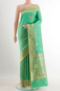 Green Banarasi Katan Silk Saree with Zari Butta on the body and Zari Border.  displayed on a mannequin