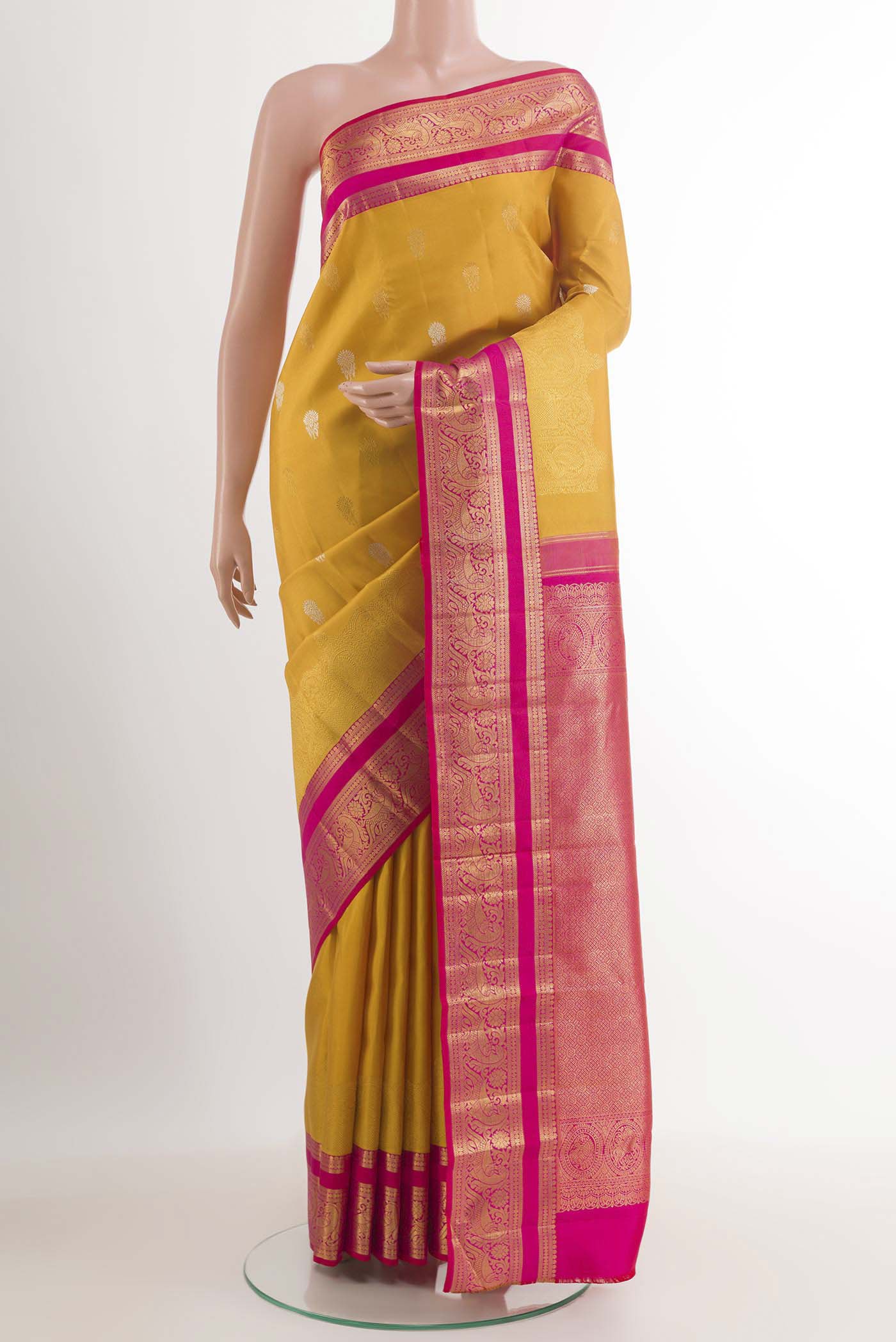 Yellow Kanchipuram Silk Saree with Zari Butta on the body and Ganga Jamuna Border.  displayed on a mannequin