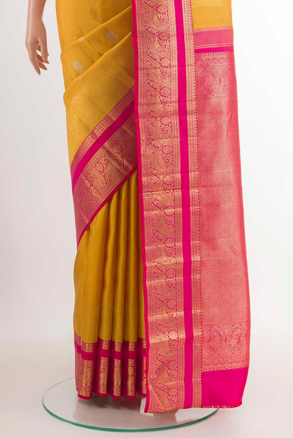 Pleats and pallu of Yellow Kanchipuram Silk Saree with Zari Butta on the body and Ganga Jamuna Border. 