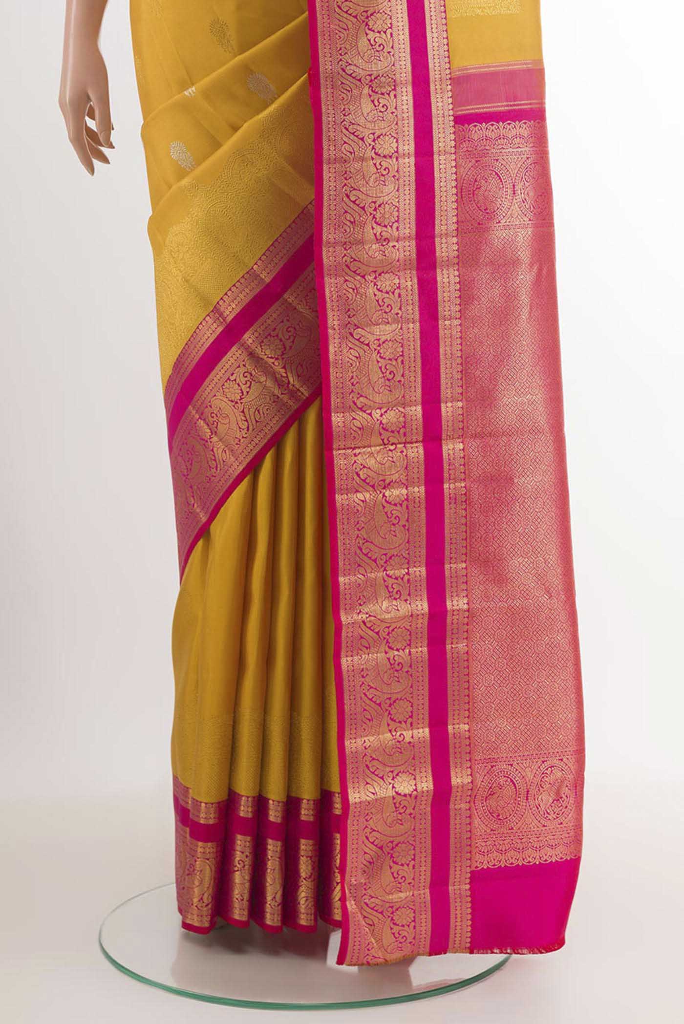 Pleats and pallu of Yellow Kanchipuram Silk Saree with Zari Butta on the body and Ganga Jamuna Border. 