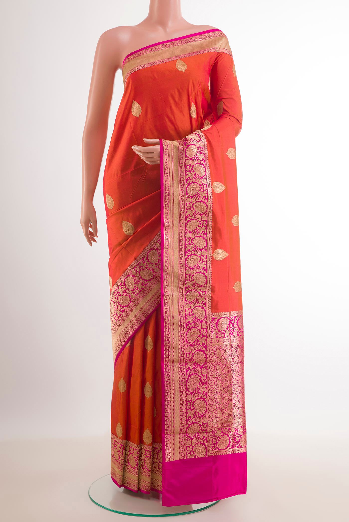 Orange Banarasi Katan Silk Saree with Zari Butta on the body and Zari Border.  displayed on a mannequin
