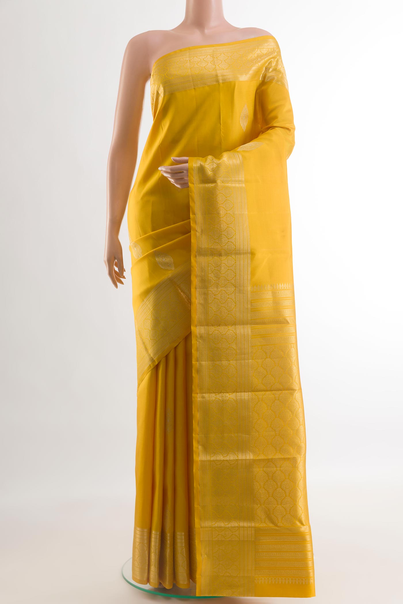 Yellow Kanchipuram Silk Saree with Zari Butta on the body and Zari Border.  displayed on a mannequin