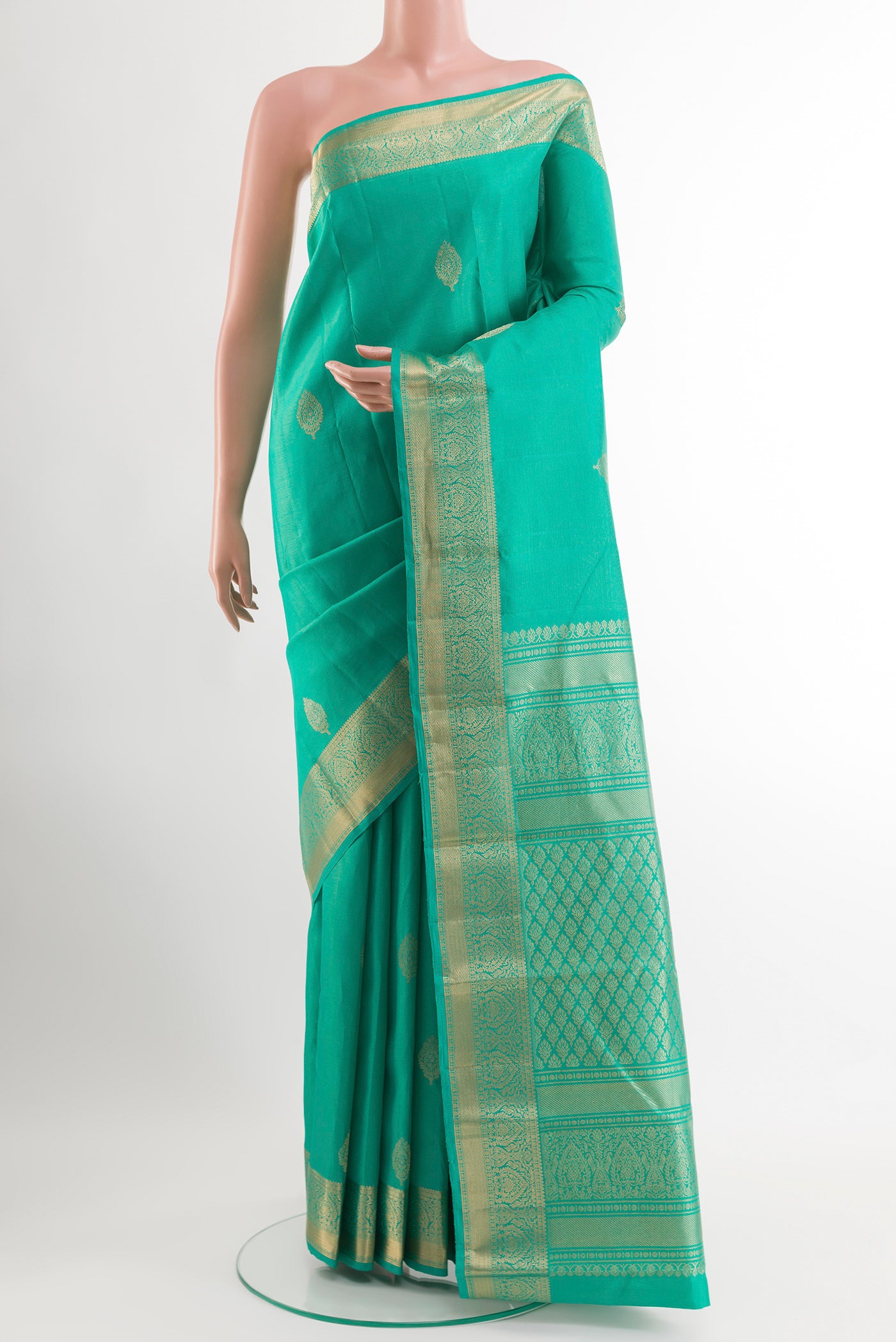 Green Kanchipuram Silk Saree with Zari Butta on the body and Zari Border.  displayed on a mannequin