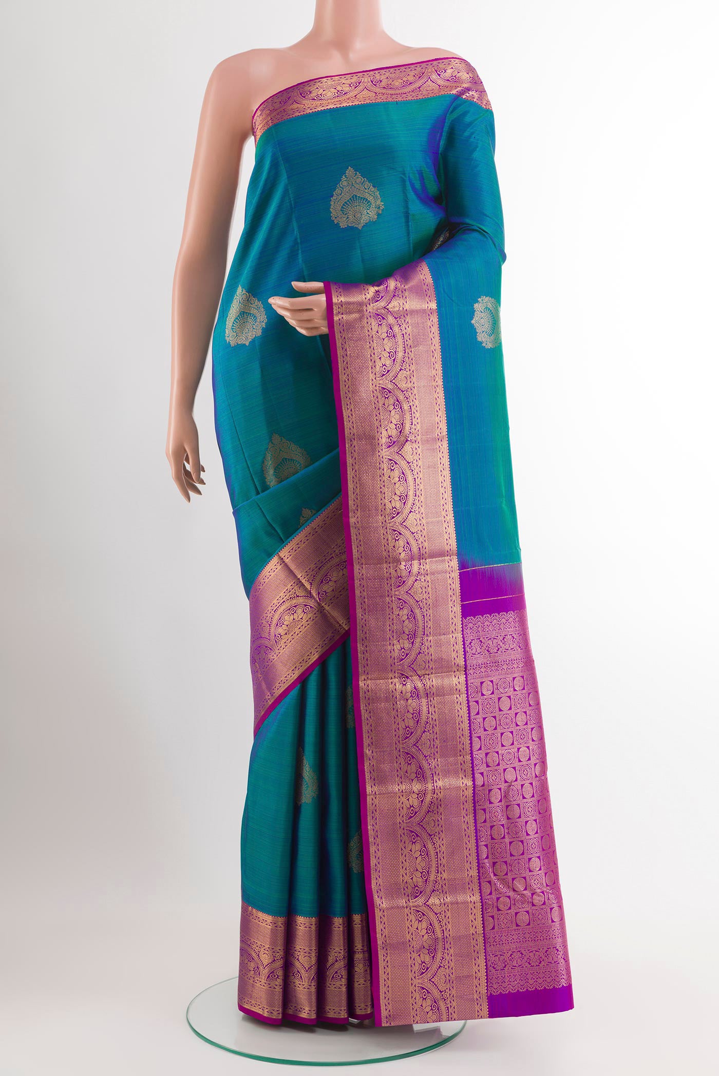 Peacock Blue Kanchipuram Silk Saree with Zari Butta on the body and Zari Border.  displayed on a mannequin