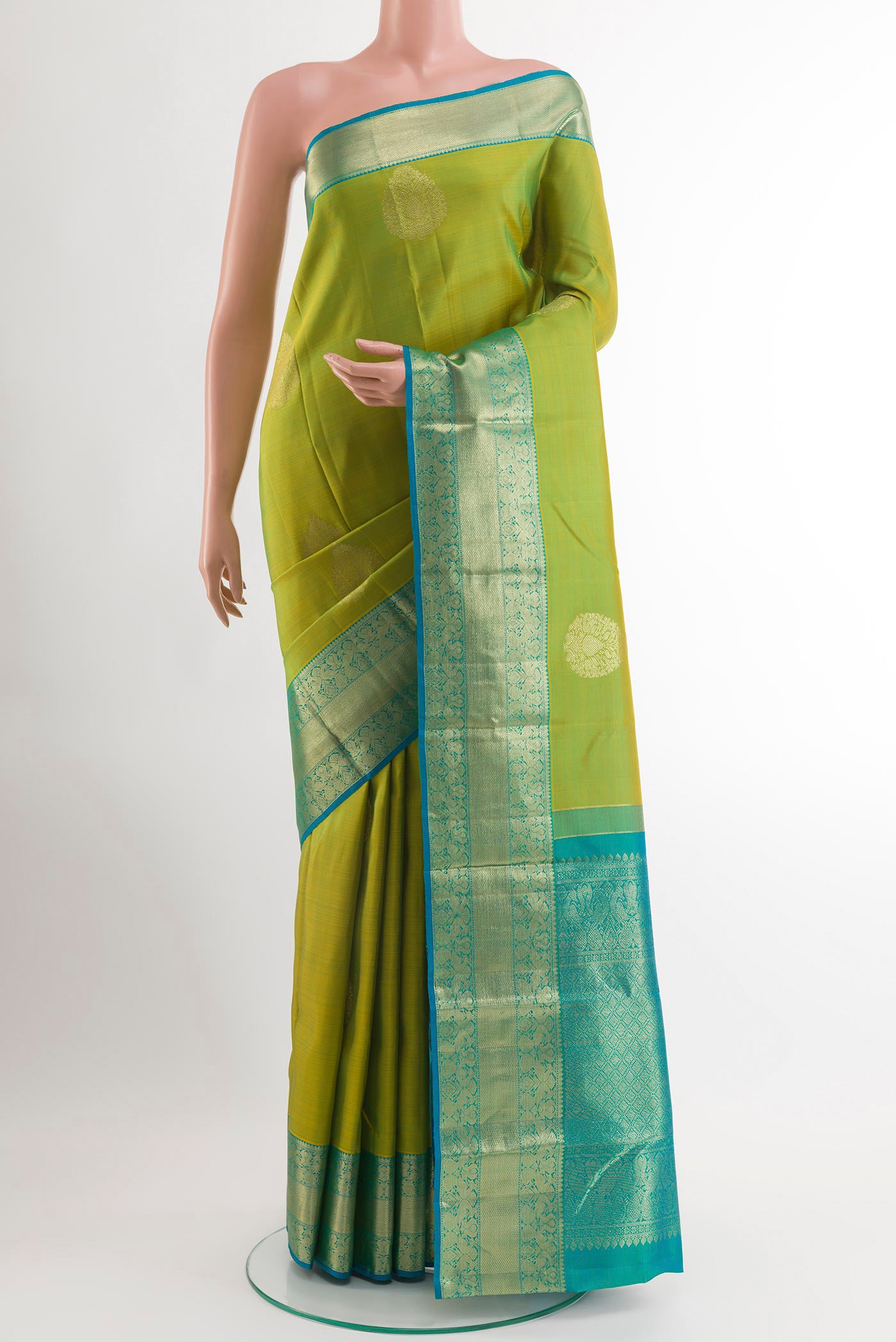 Green Kanchipuram Silk Saree with Zari Butta on the body and Zari Border.  displayed on a mannequin