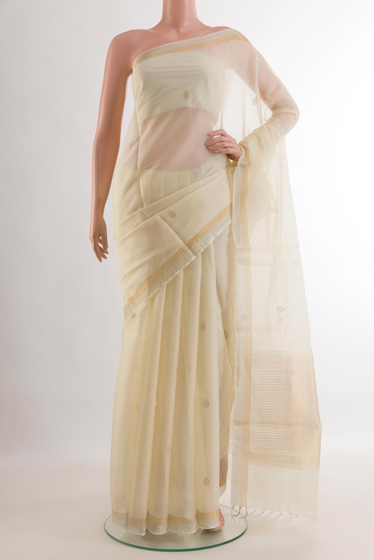 Off White Tussar Silk Saree with Zari Butta on the body and Zari Border.  displayed on a mannequin