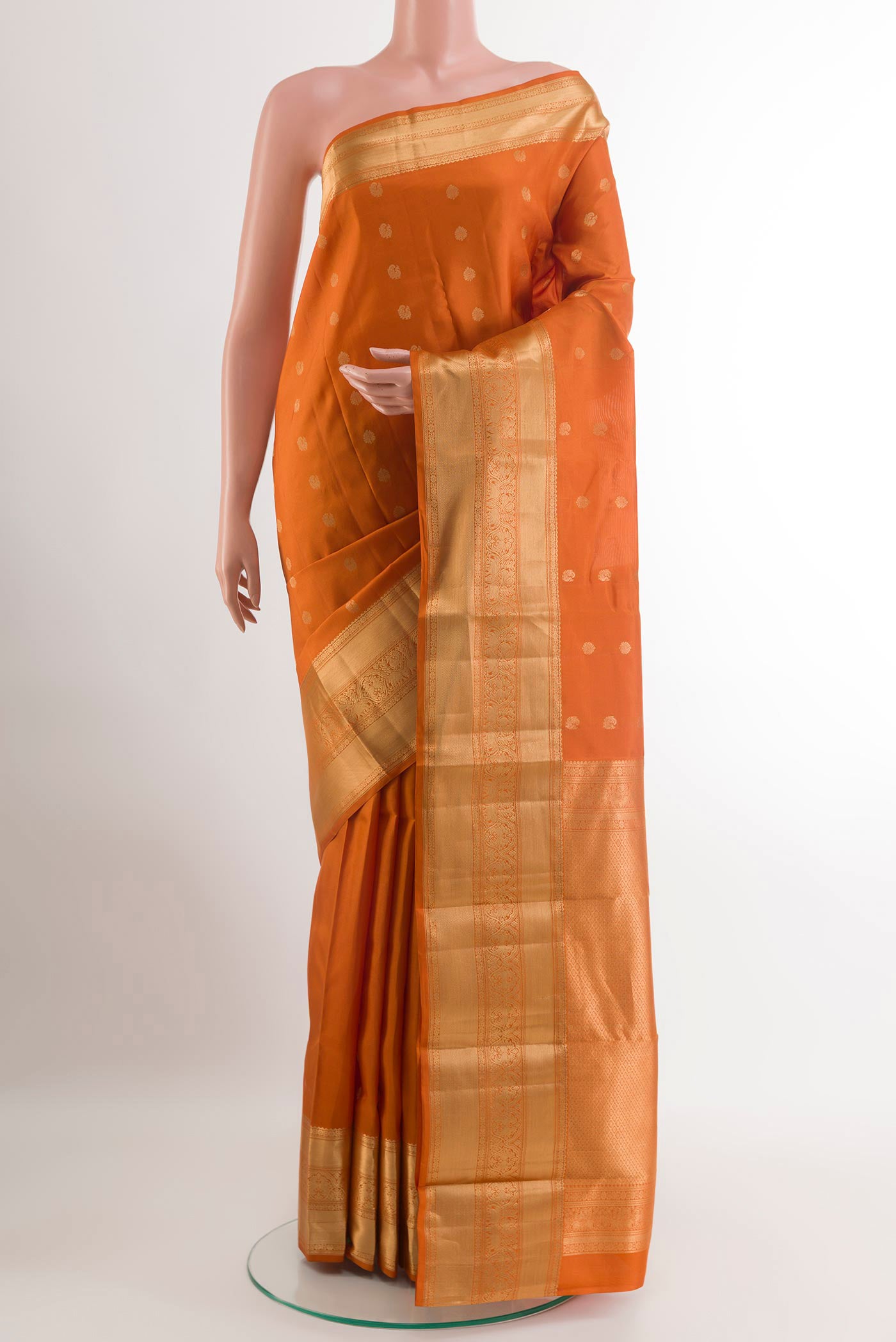 Mustard Kanchipuram Silk Saree with Zari Butta on the body and Zari Border.  displayed on a mannequin