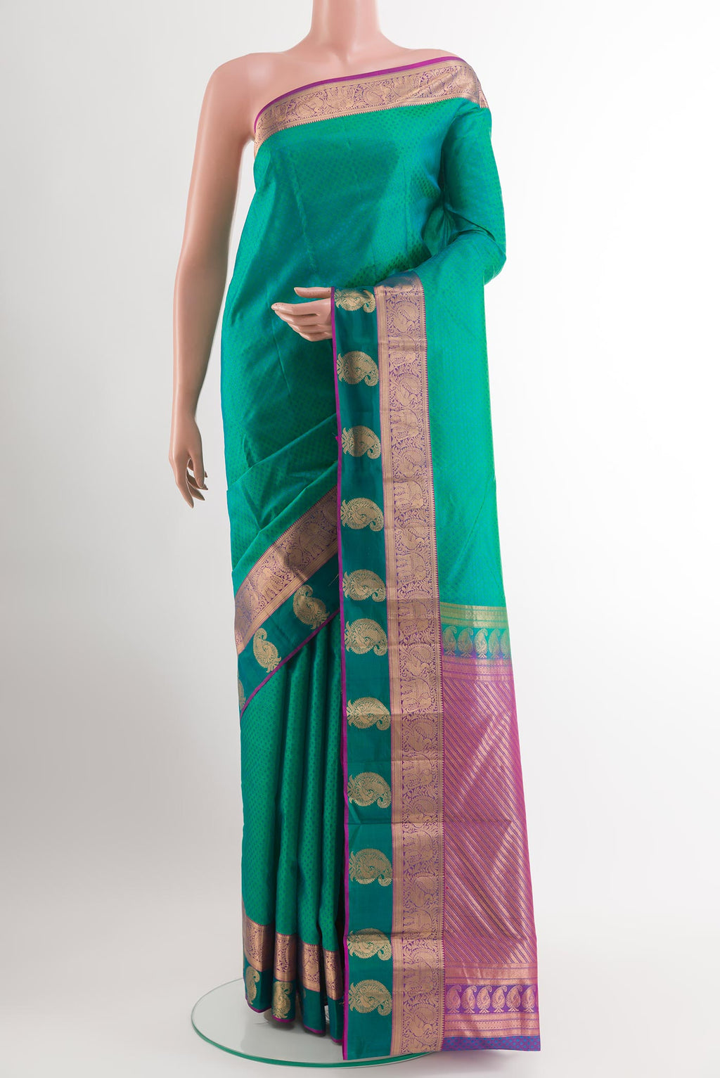 Green Kanjivaram Silk Saree with Jacquard design on the body and Zari Border.  displayed on a mannequin