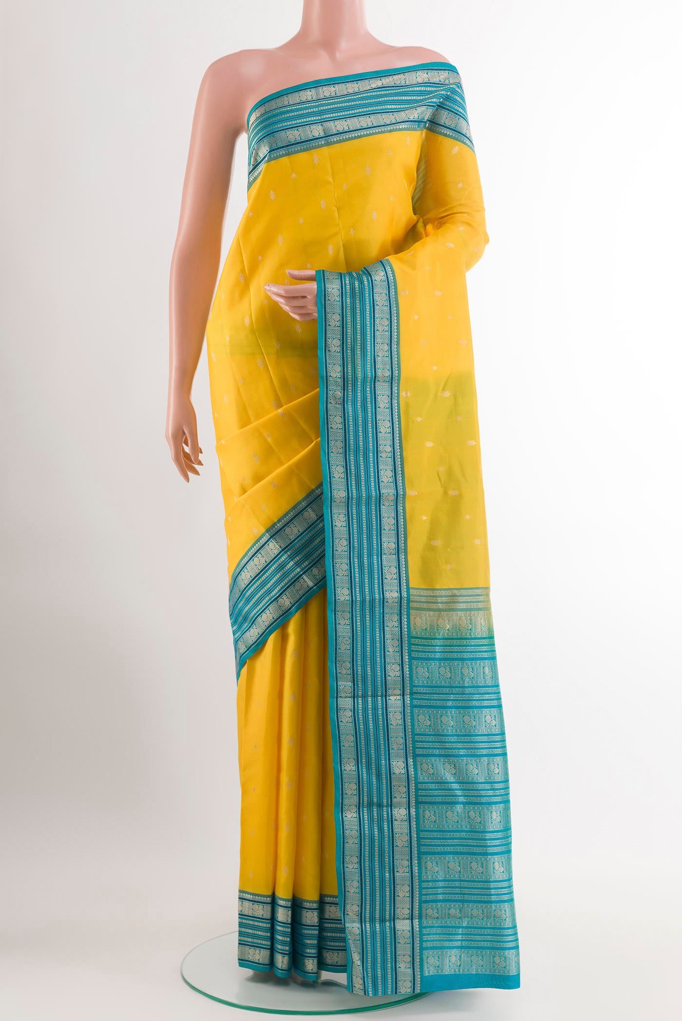 Yellow Kanjivaram Silk Saree with Zari Butta on the body and Zari Border.  displayed on a mannequin