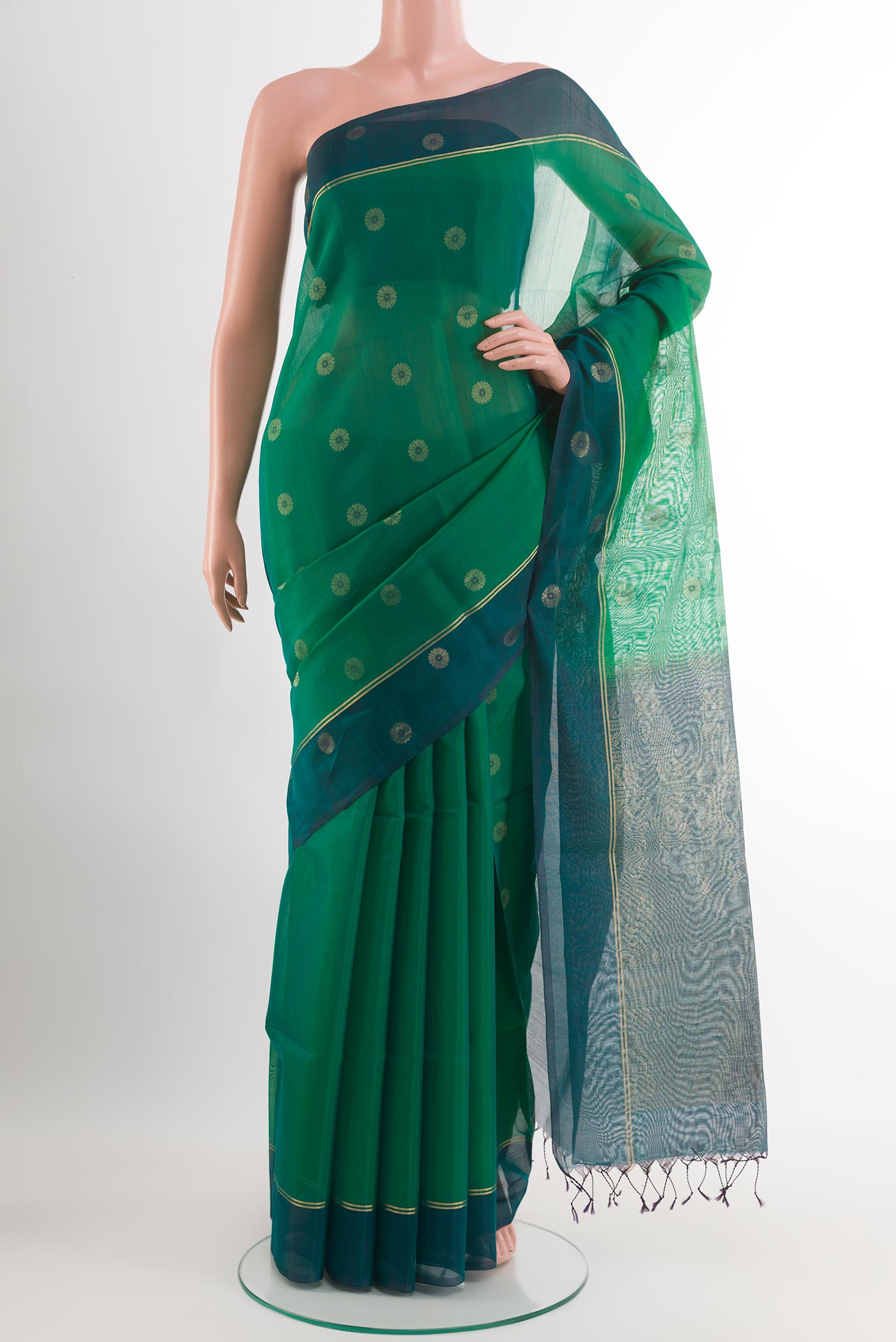 Green Blended Kora Cotton Saree with Zari Butta on the body and Zari Border.  displayed on a mannequin