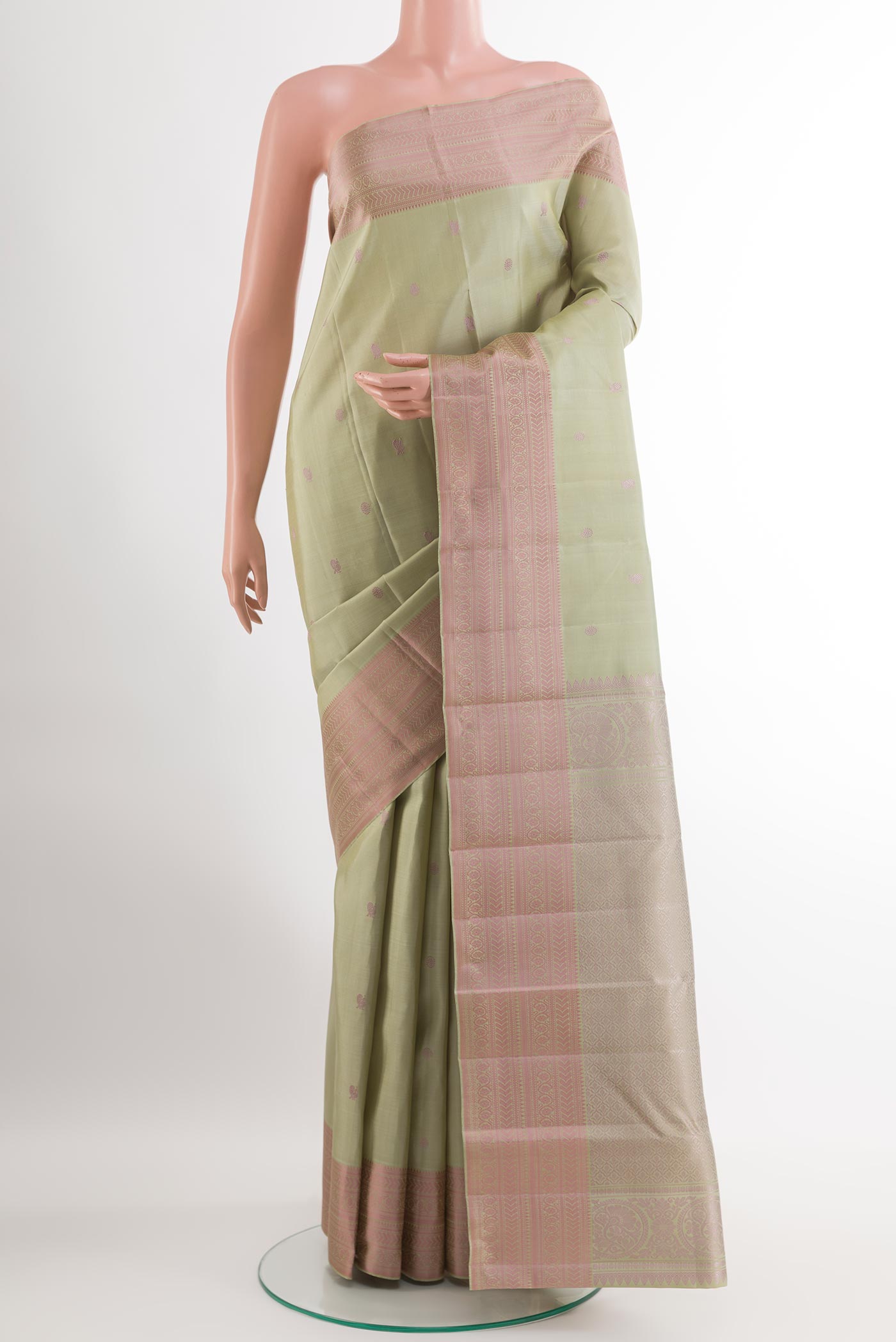 Sage Green Kanchipuram Silk Saree with Thread Butta on the body and Thread Embroidery Border.  displayed on a mannequin