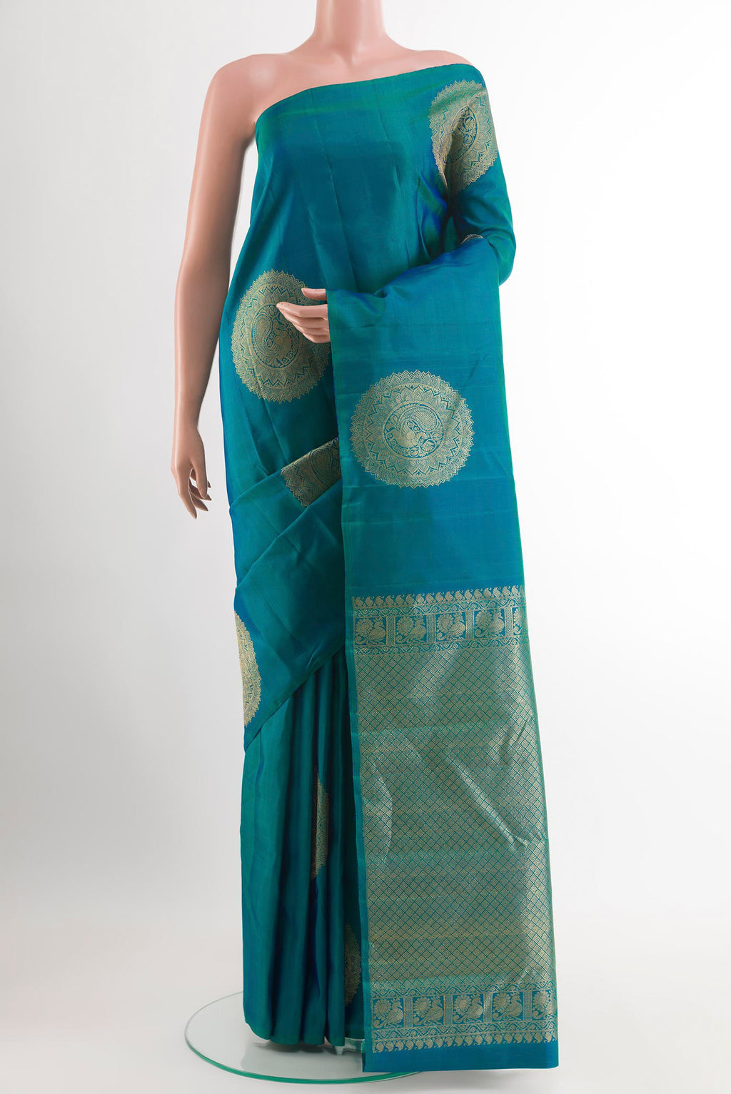 Peacock Blue Kanchipuram Silk Saree with Zari Butta on the body and Zari Border.  displayed on a mannequin