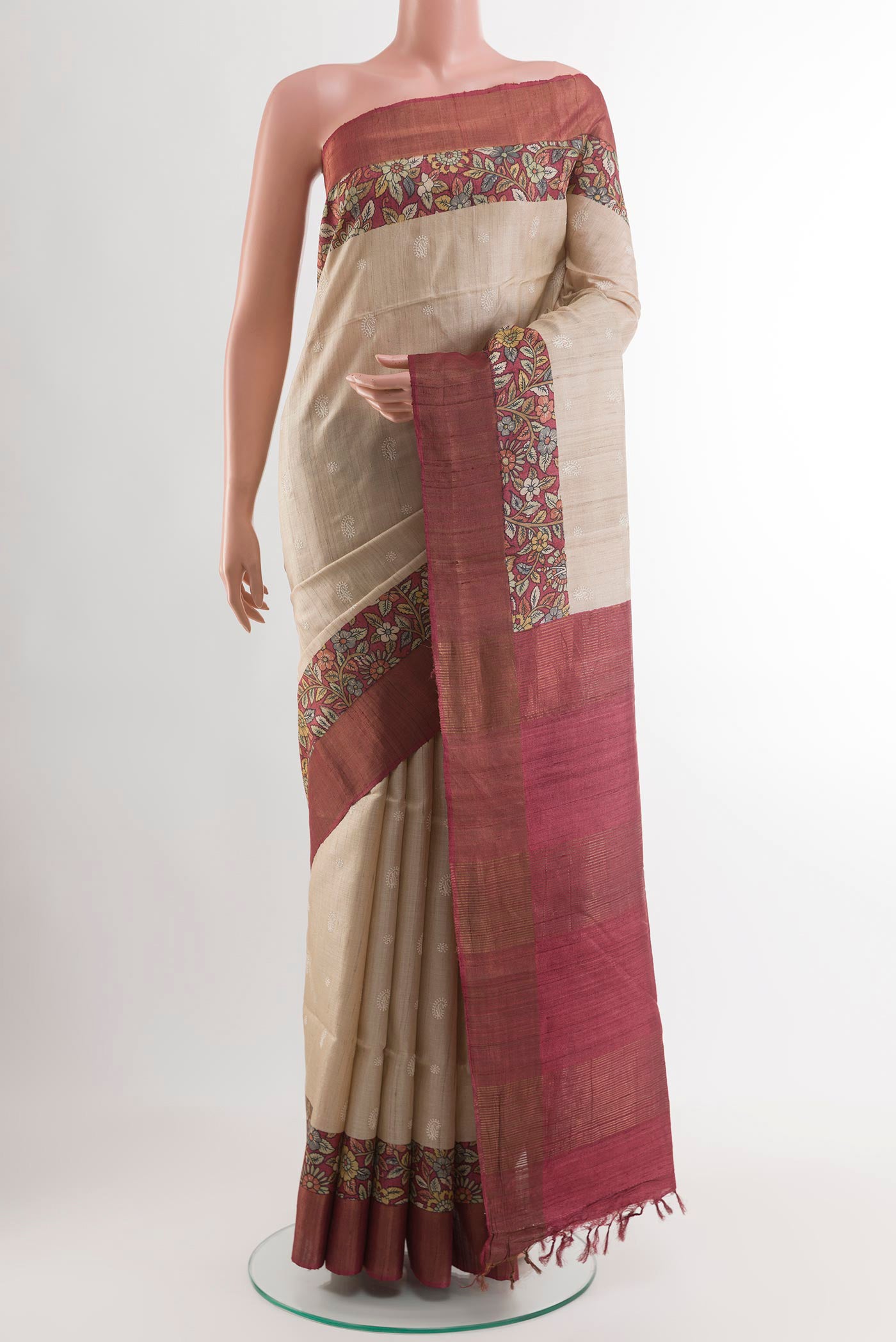 Cream Tussar Saree with Thread Butta on the body and Zari Border.  displayed on a mannequin