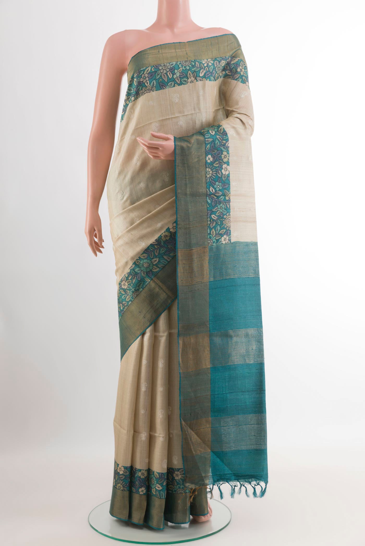 Off White Tussar Saree with Thread Butta on the body and Zari Border.  displayed on a mannequin