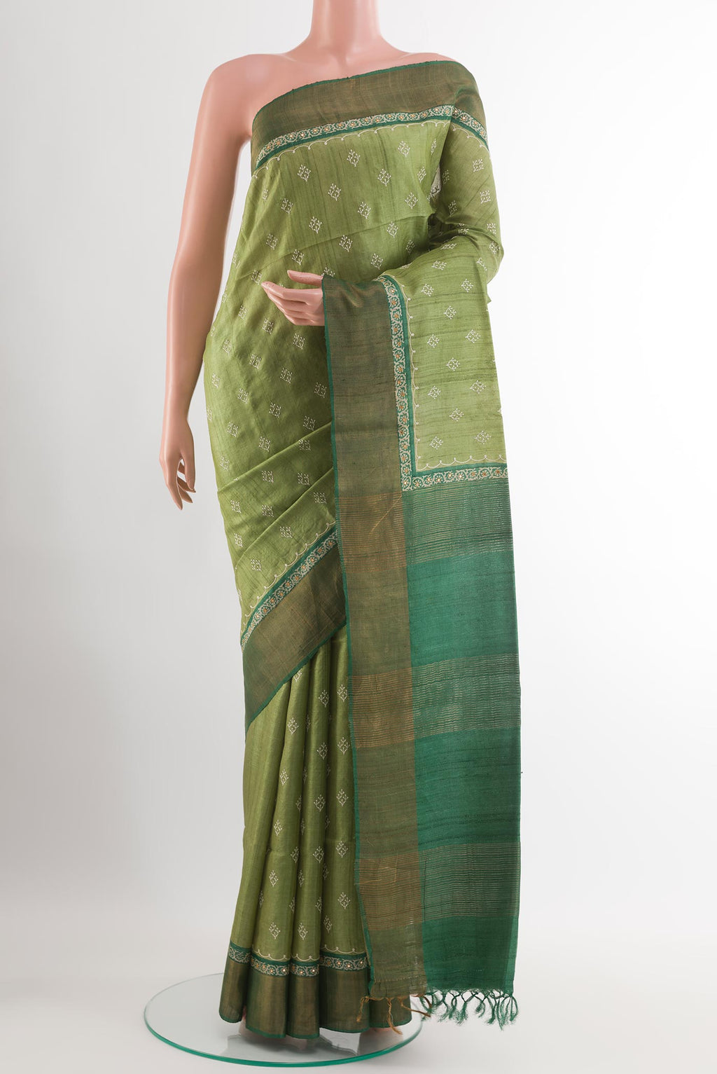 Green Tussar Saree with Thread Butta on the body and Zari Border.  displayed on a mannequin