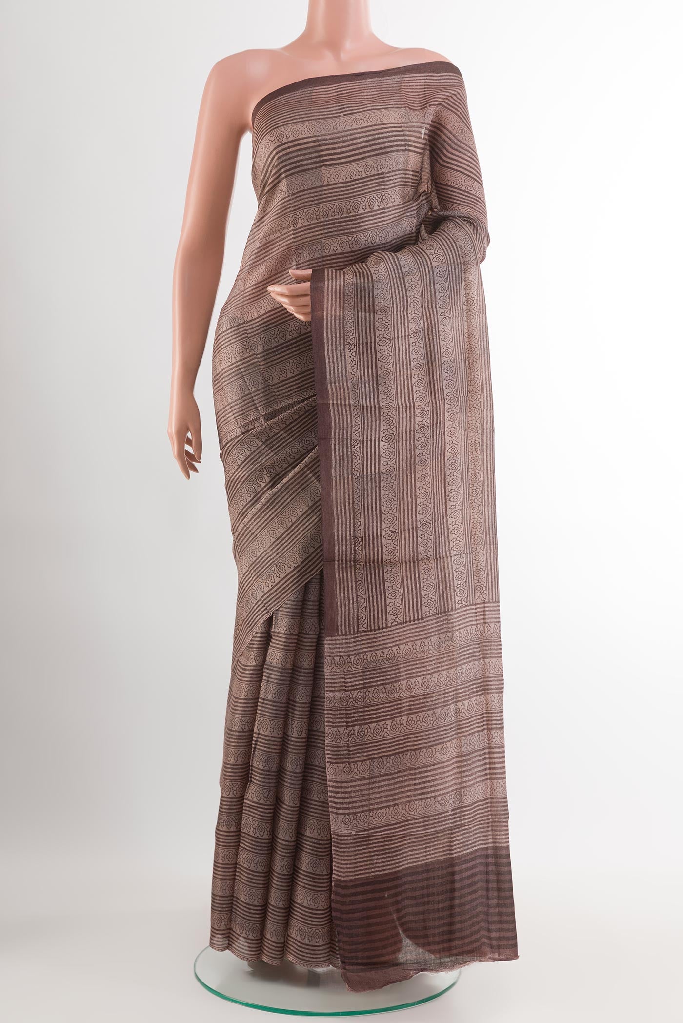 Brown Tussar Saree with Printed design on the body and Printed Border.  displayed on a mannequin