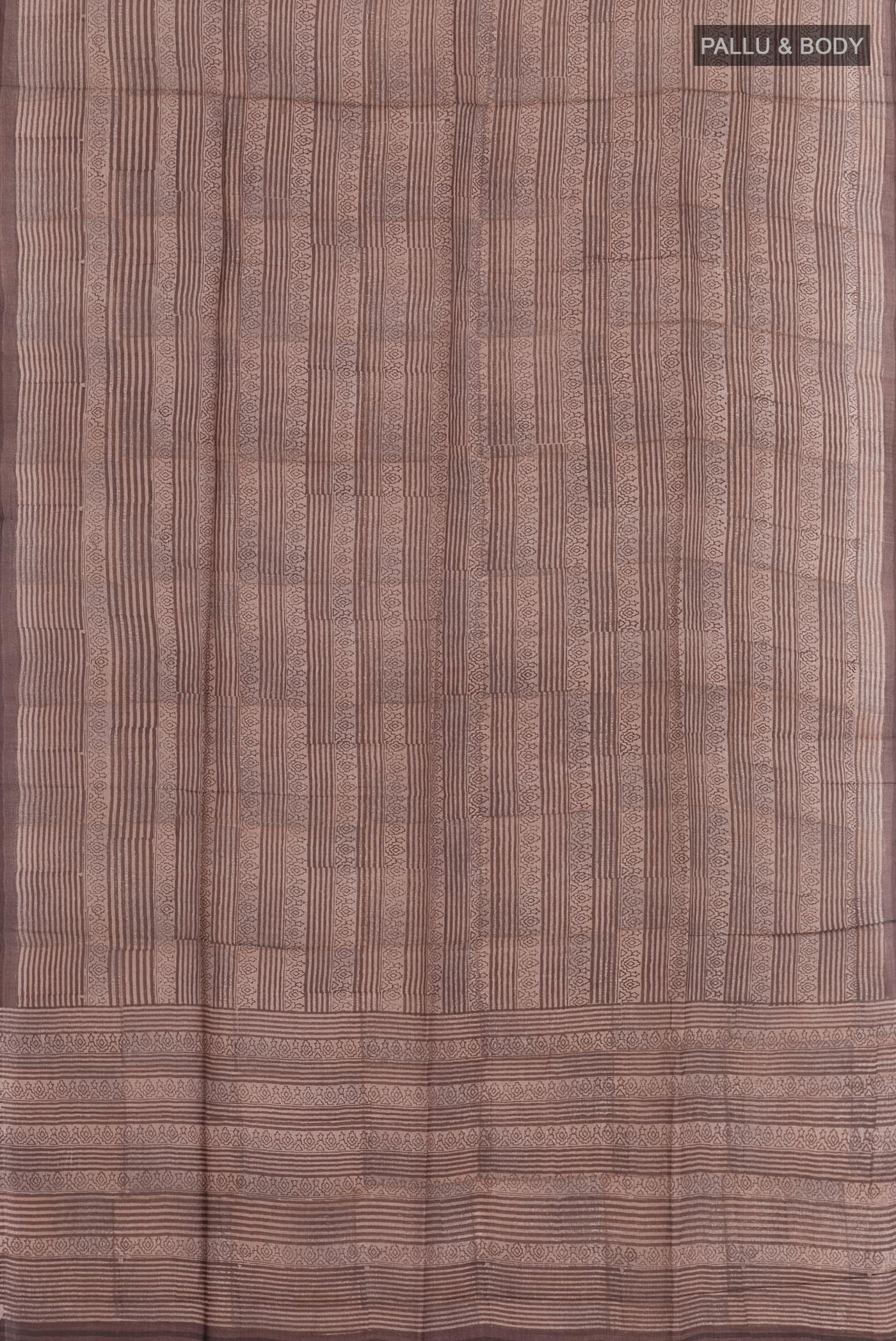 Flat view of Brown Tussar Saree with Printed design on the body and Printed Border. 
