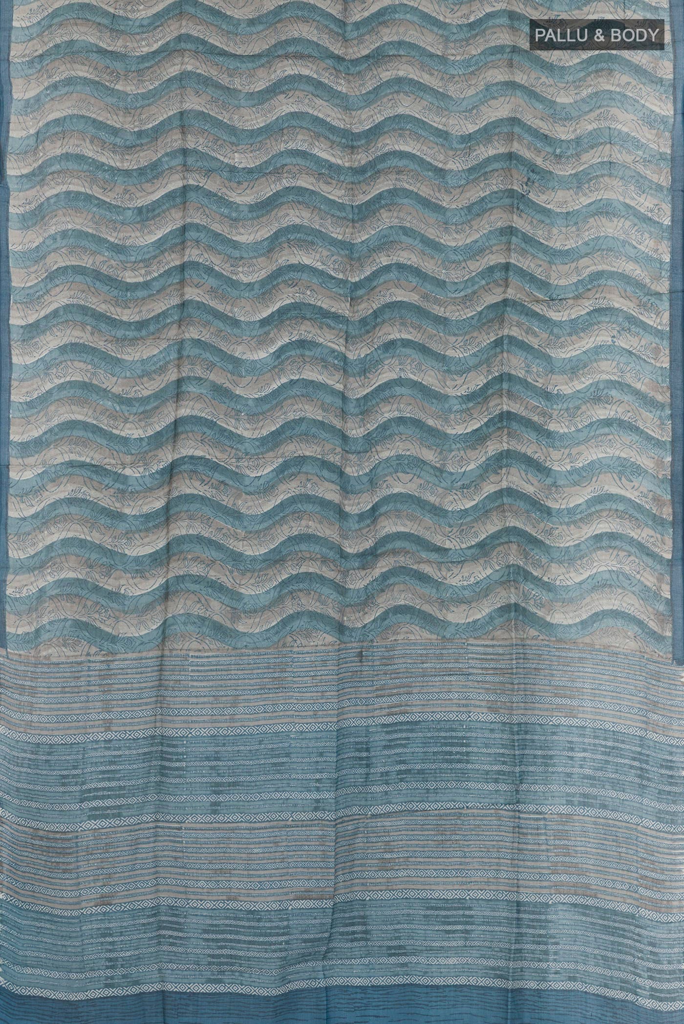 Flat view of Blue Tussar Saree with Printed design on the body and Zari Border. 