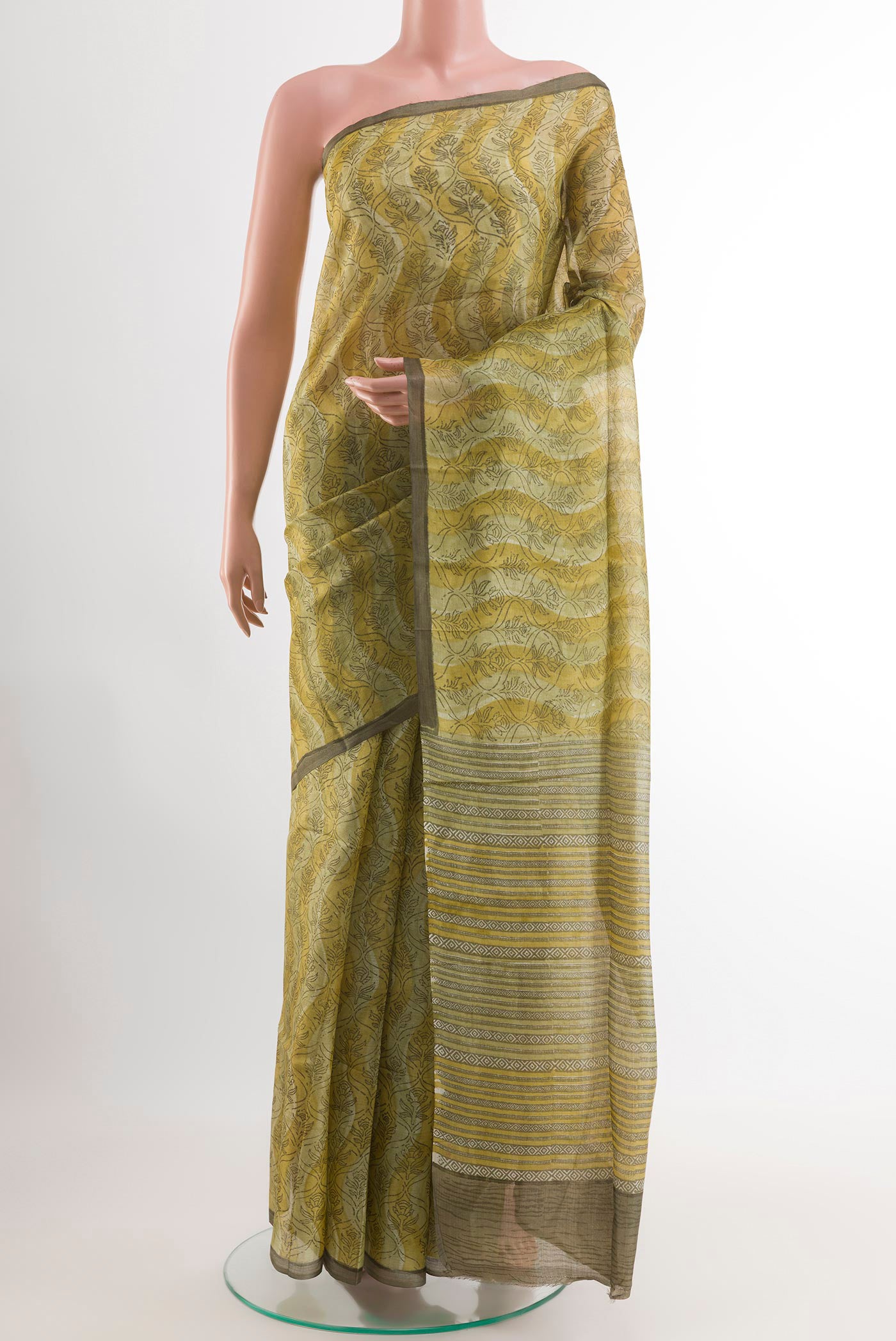 Green Tussar Saree with Printed design on the body and Printed Border.  displayed on a mannequin
