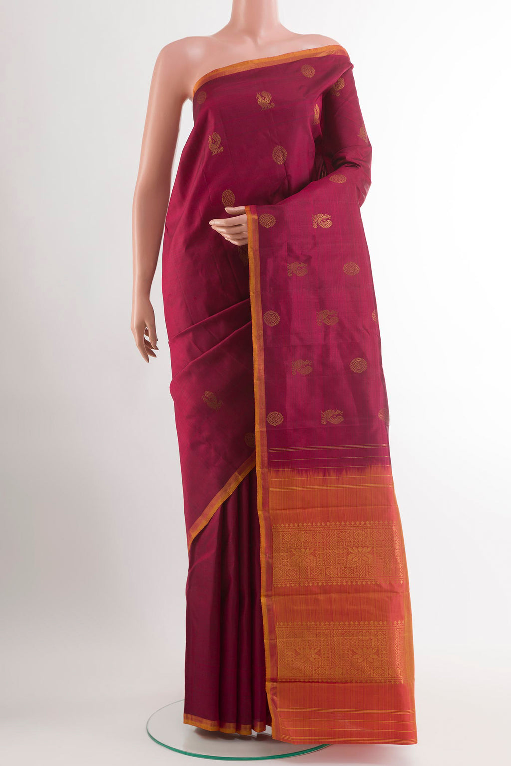 Maroon Kanchipuram Silk Saree with Zari Butta on the body and Zari Border.  displayed on a mannequin