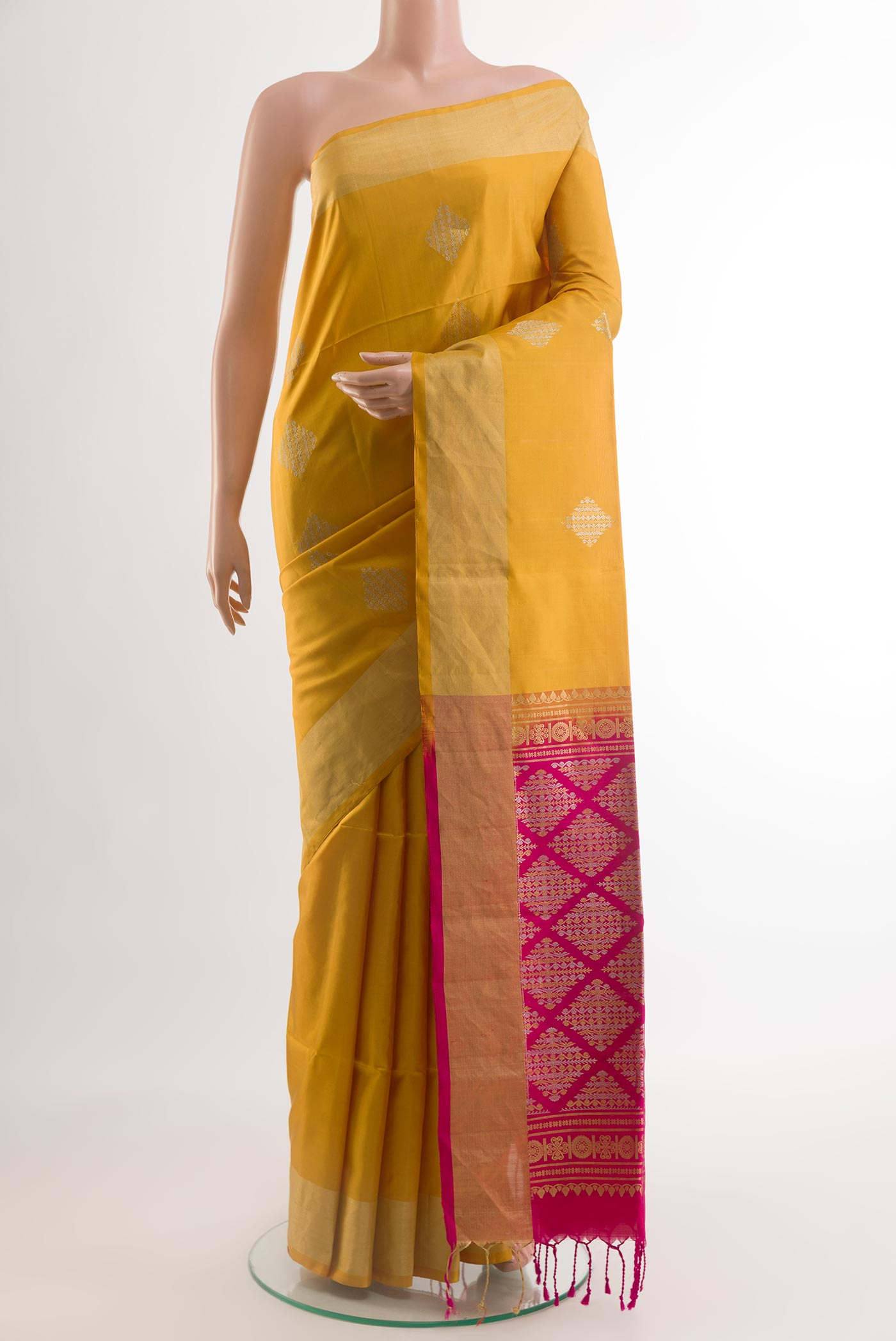 Yellow Soft Silk Saree with Zari Butta on the body and Zari Border.  displayed on a mannequin