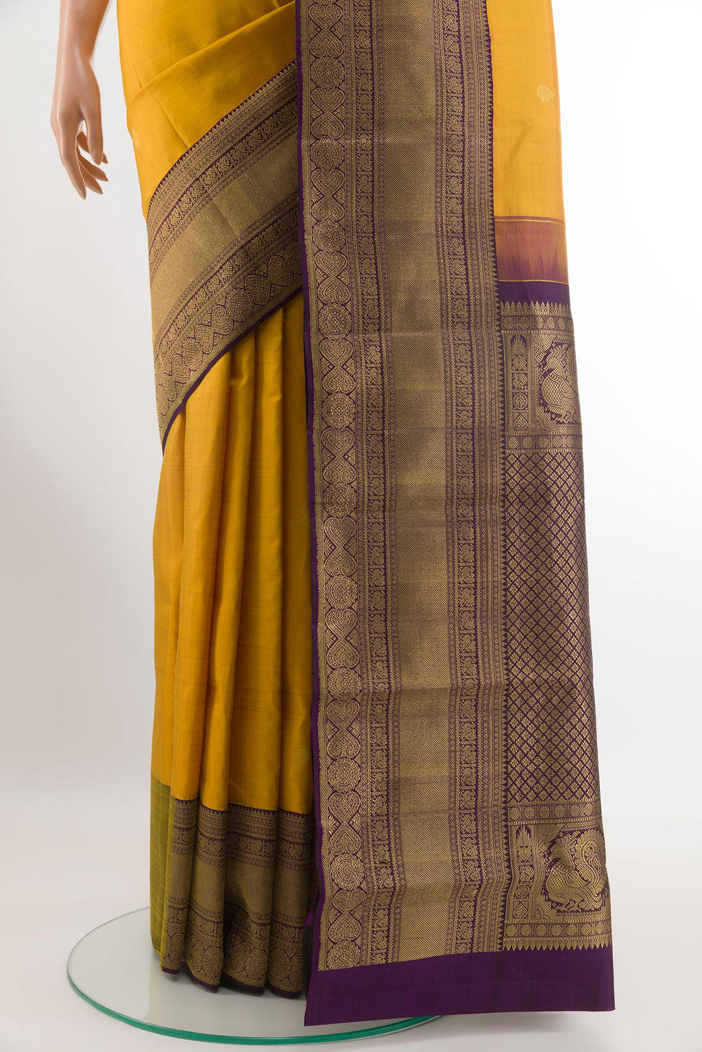 Pleats and pallu of Mustard Kanchipuram Silk Saree with Zari Butta on the body and Zari Border. 