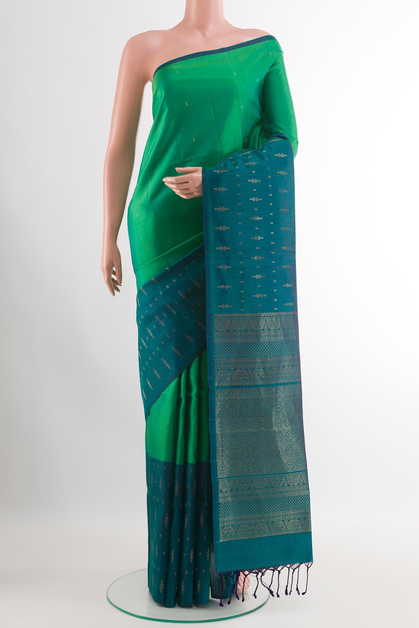 Green Soft Silk Saree with Zari Butta on the body and Zari Border.  displayed on a mannequin