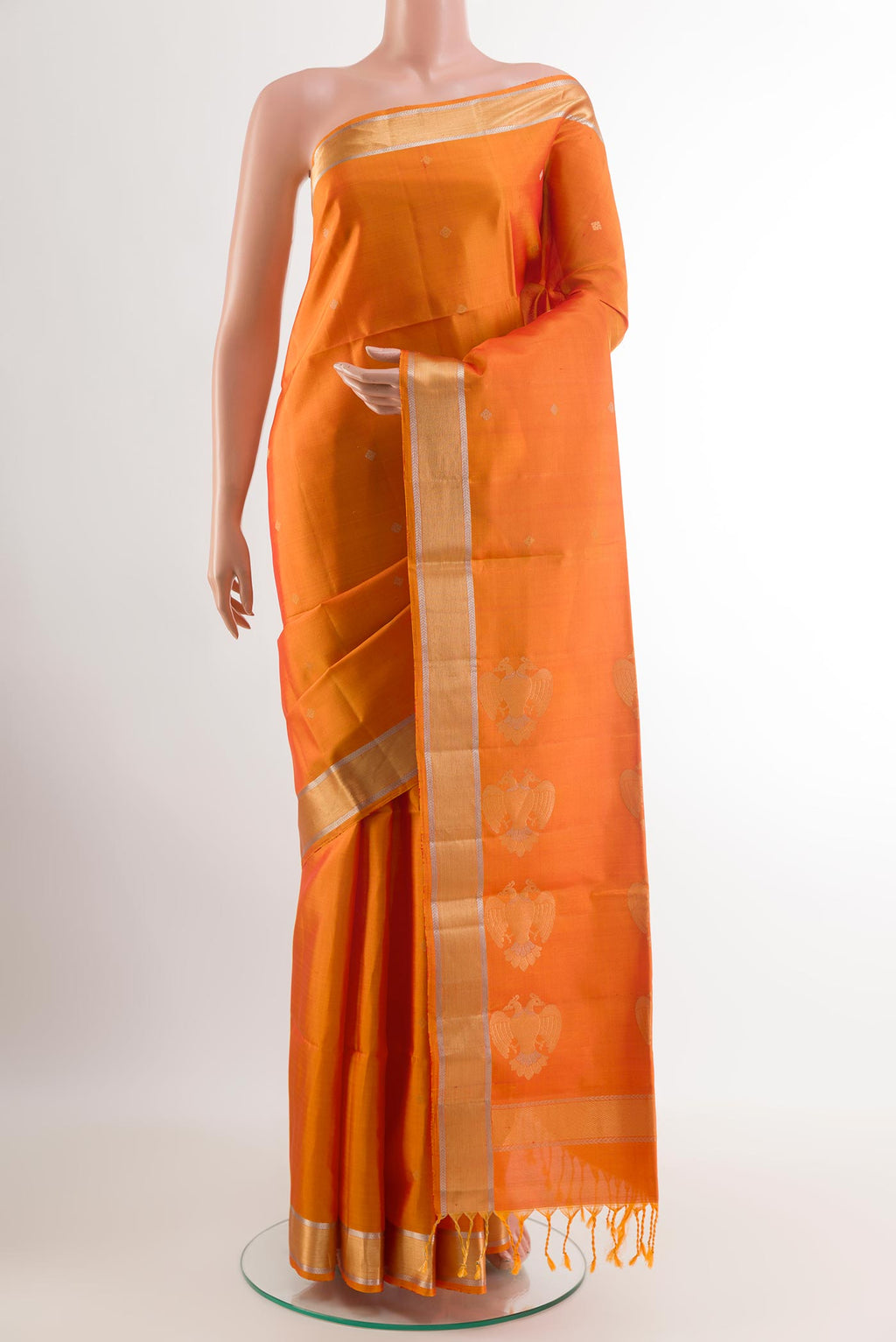 Orange Soft Silk Saree with Zari Butta on the body and Zari Border.  displayed on a mannequin