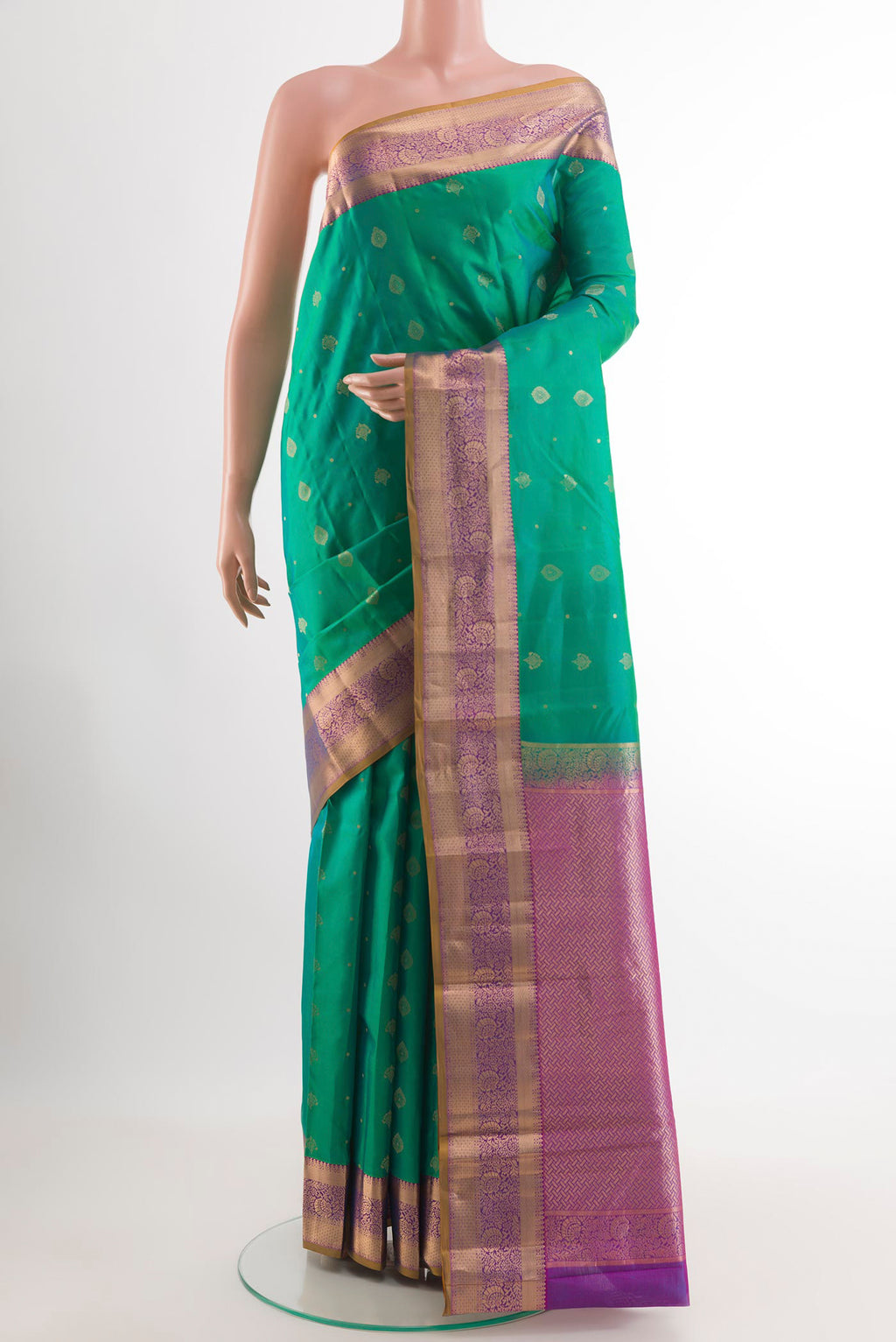 Green Kanchipuram Silk Saree with Zari Butta on the body and Zari Border.  displayed on a mannequin