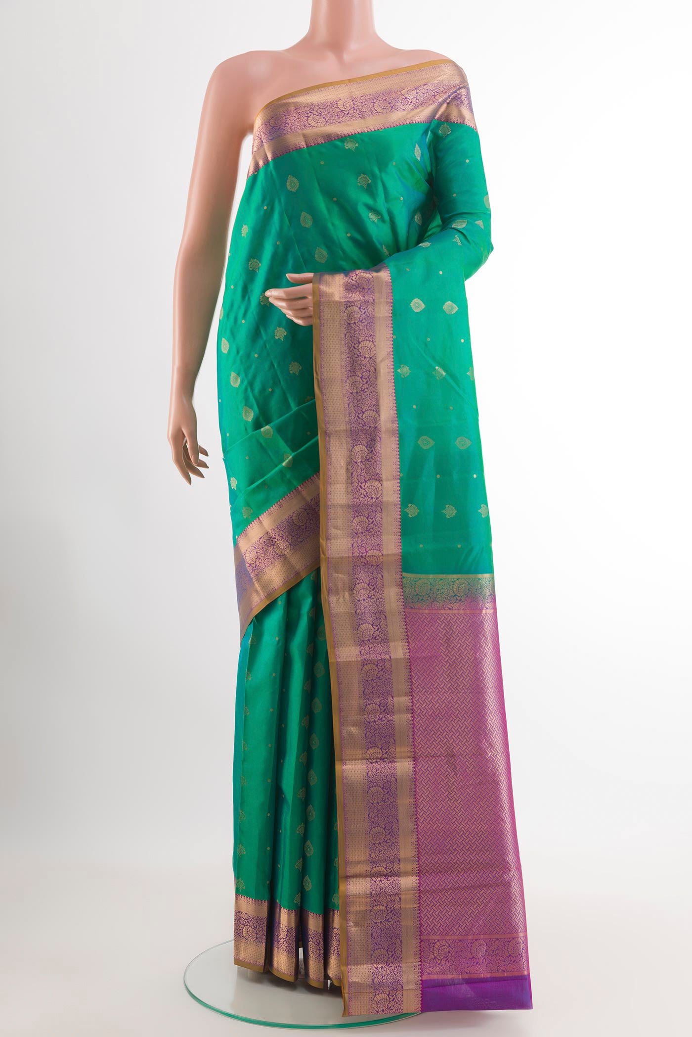 Green Kanchipuram Silk Saree with Zari Butta on the body and Zari Border.  displayed on a mannequin