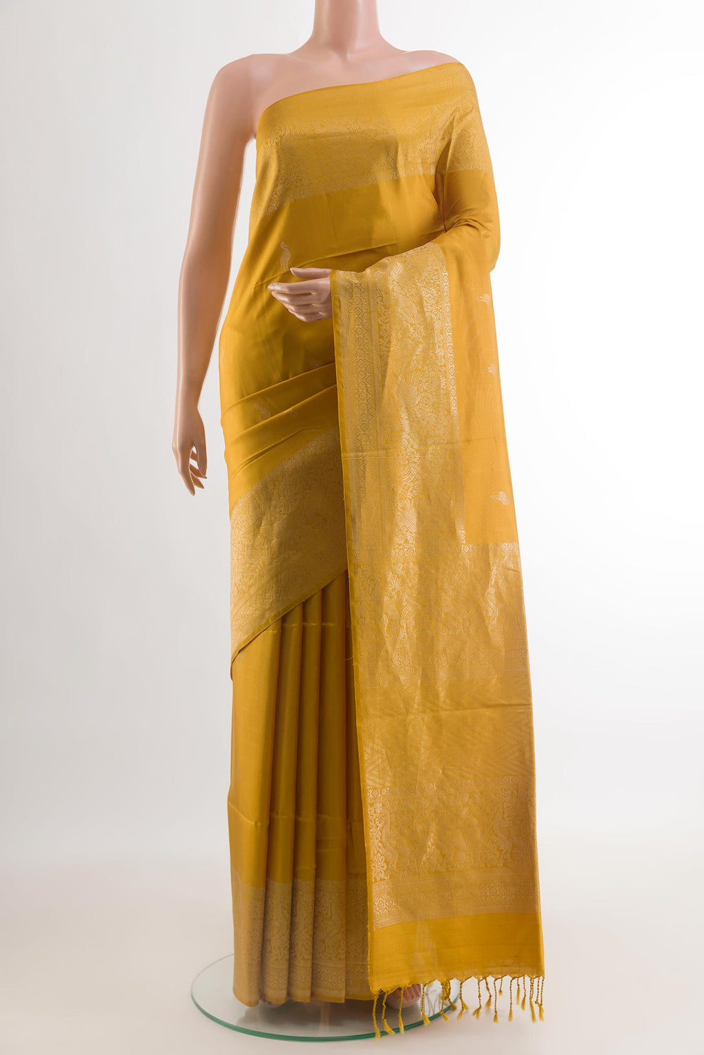 Mustard Soft Silk Saree with Zari Butta on the body and Zari Border.  displayed on a mannequin