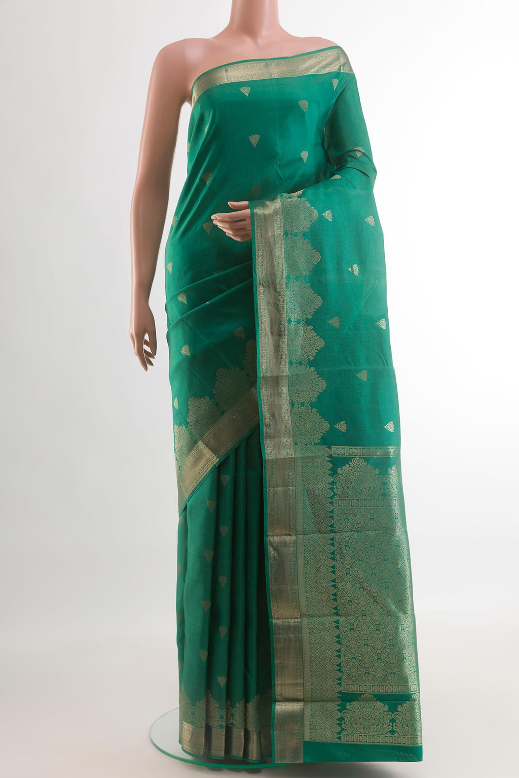 Green Kanjivaram Silk Saree with Zari Butta on the body and Zari Border.  displayed on a mannequin