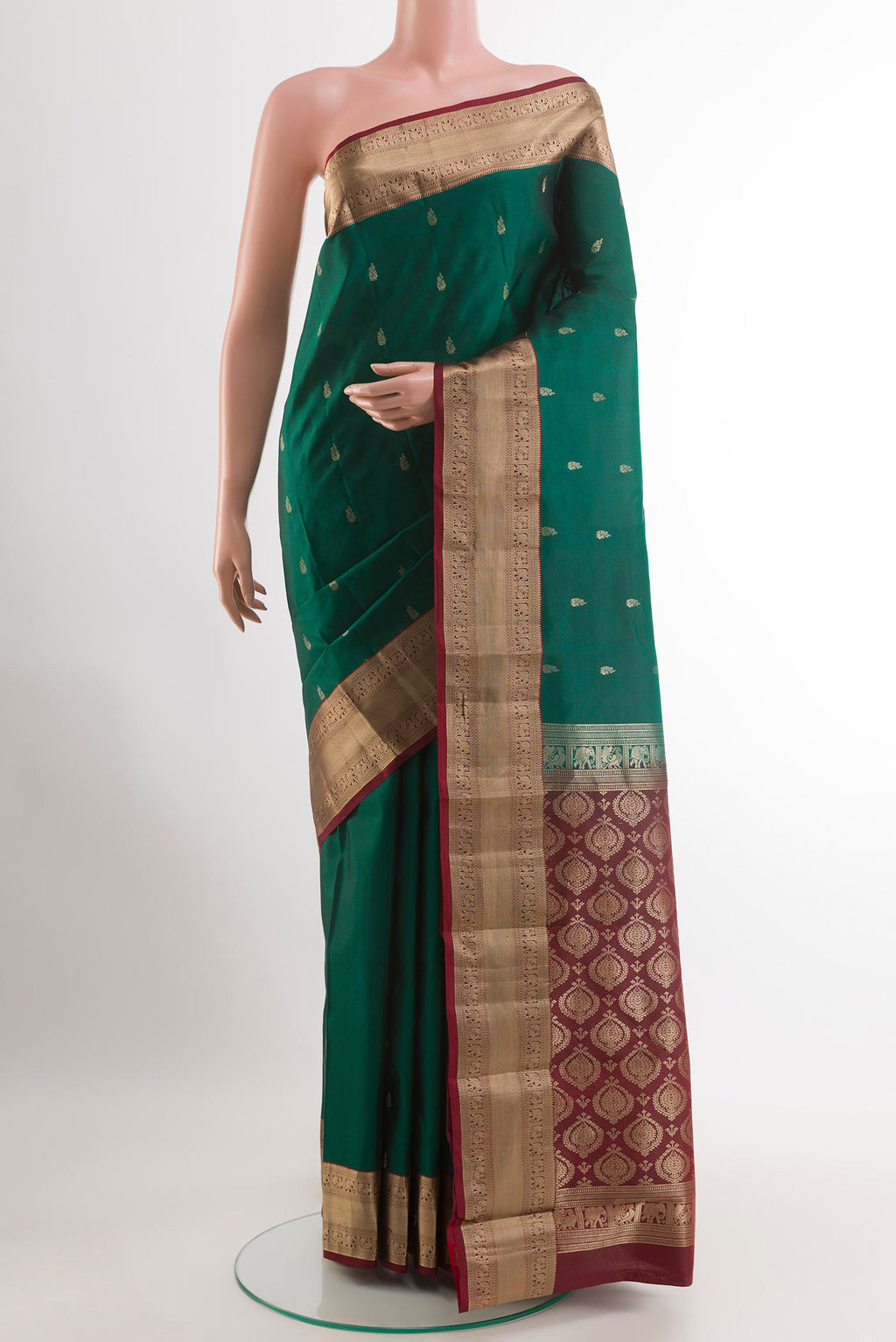 Green Kanchipuram Silk Saree with Zari Butta on the body and Zari Border.  displayed on a mannequin