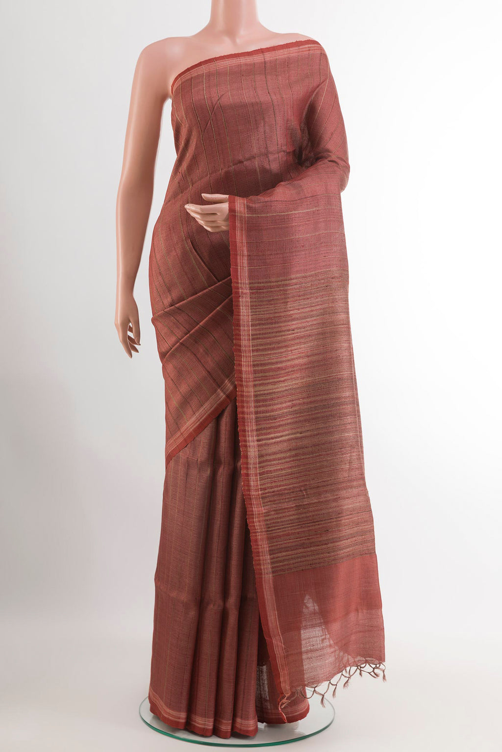 Brick Orange Tussar Saree with Printed design on the body and Zari Border.  displayed on a mannequin