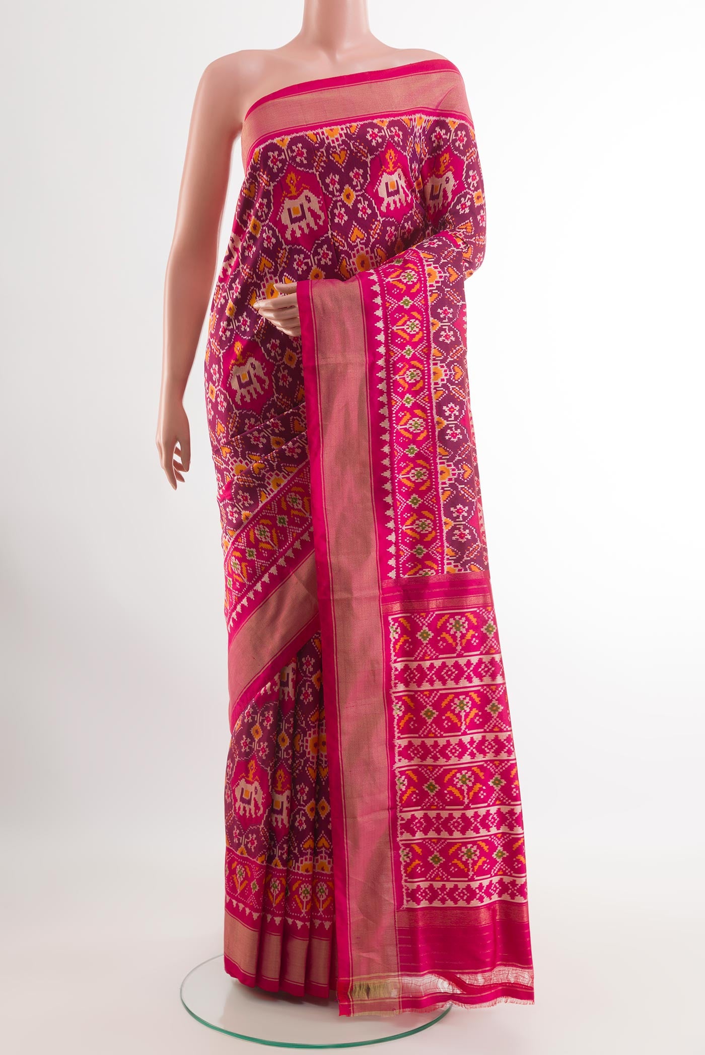 Rani Pink Pochampally Silk Saree with Ikat design on the body and Zari Border.  displayed on a mannequin