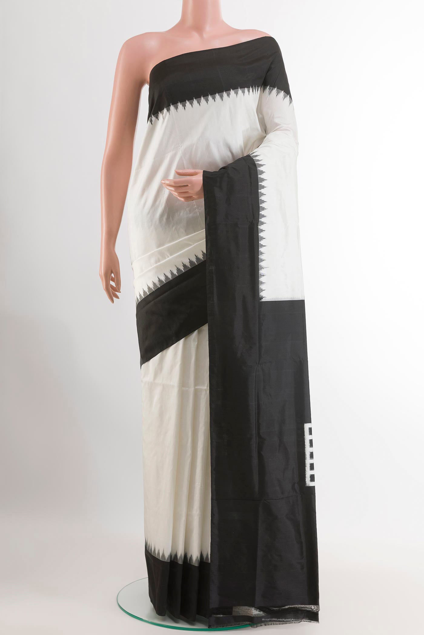 White Pochampally Silk Saree with Ikat design on the body and Zari Border.  displayed on a mannequin
