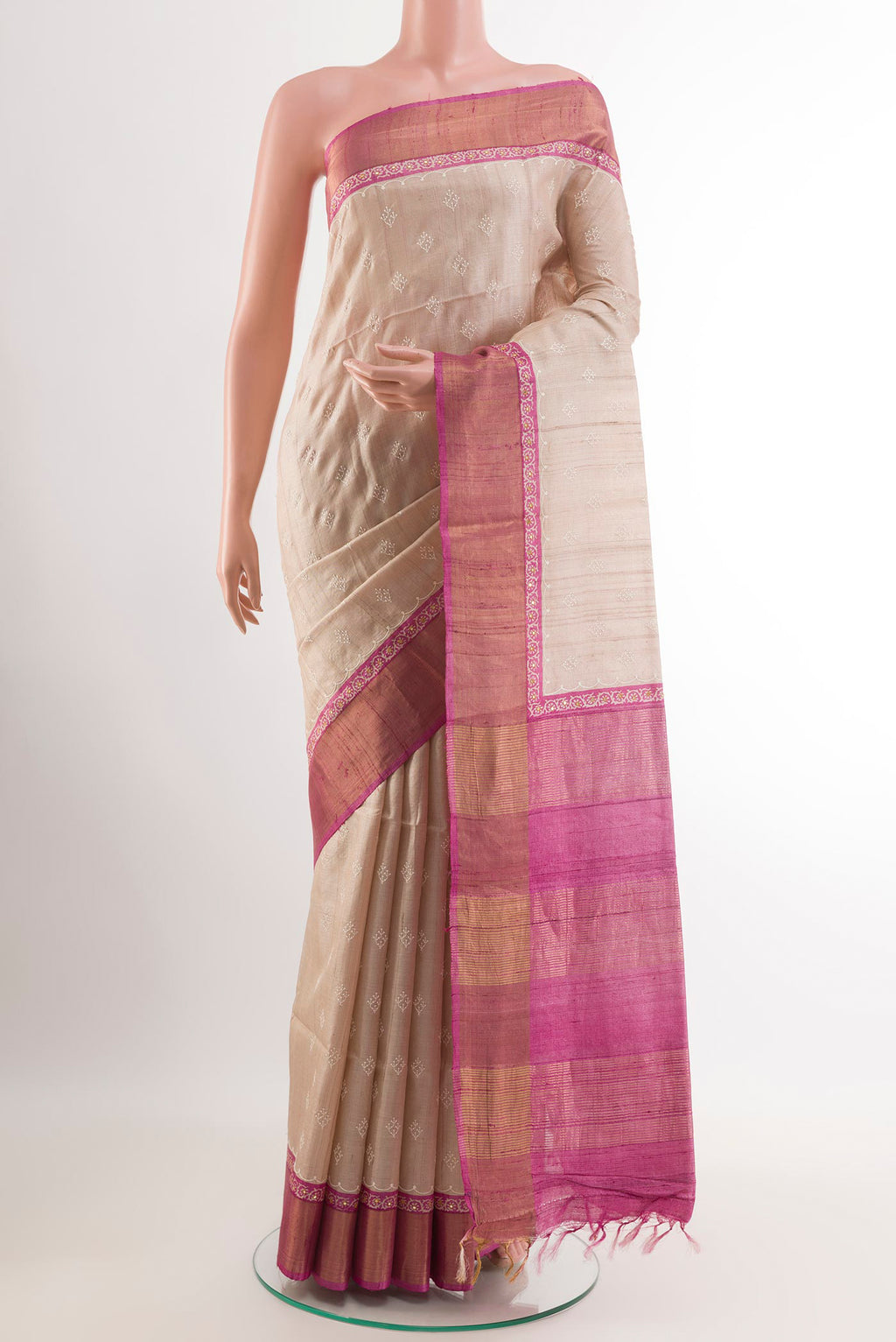 Cream Tussar Saree with Thread Butta on the body and Zari Border.  displayed on a mannequin