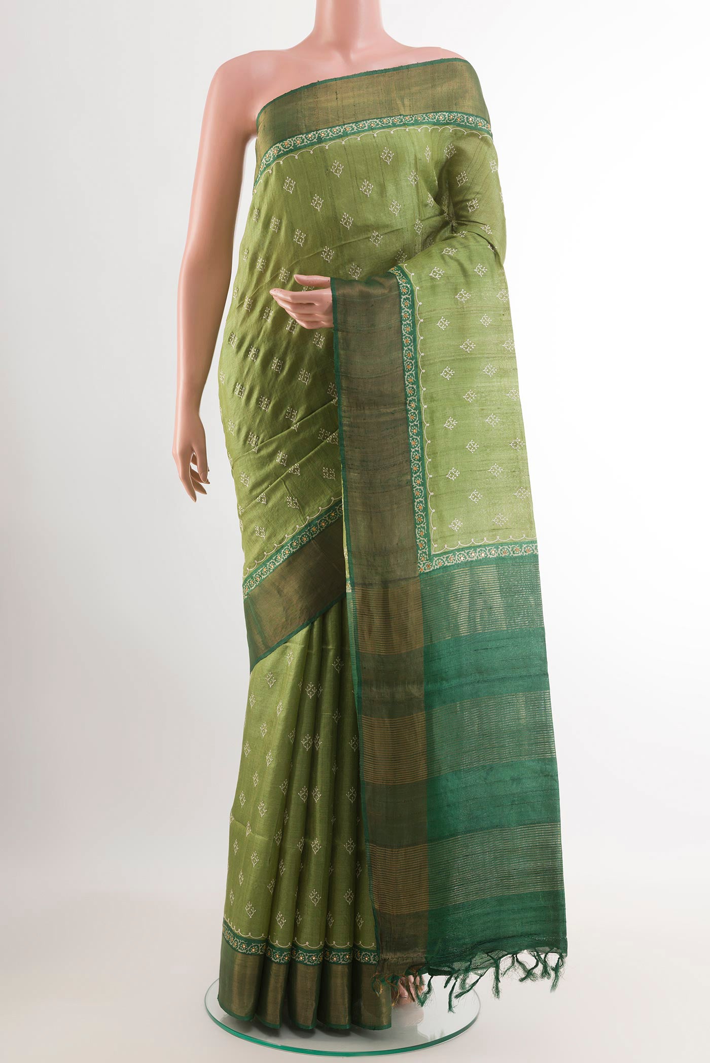 Green Tussar Saree with Thread Butta on the body and Zari Border.  displayed on a mannequin